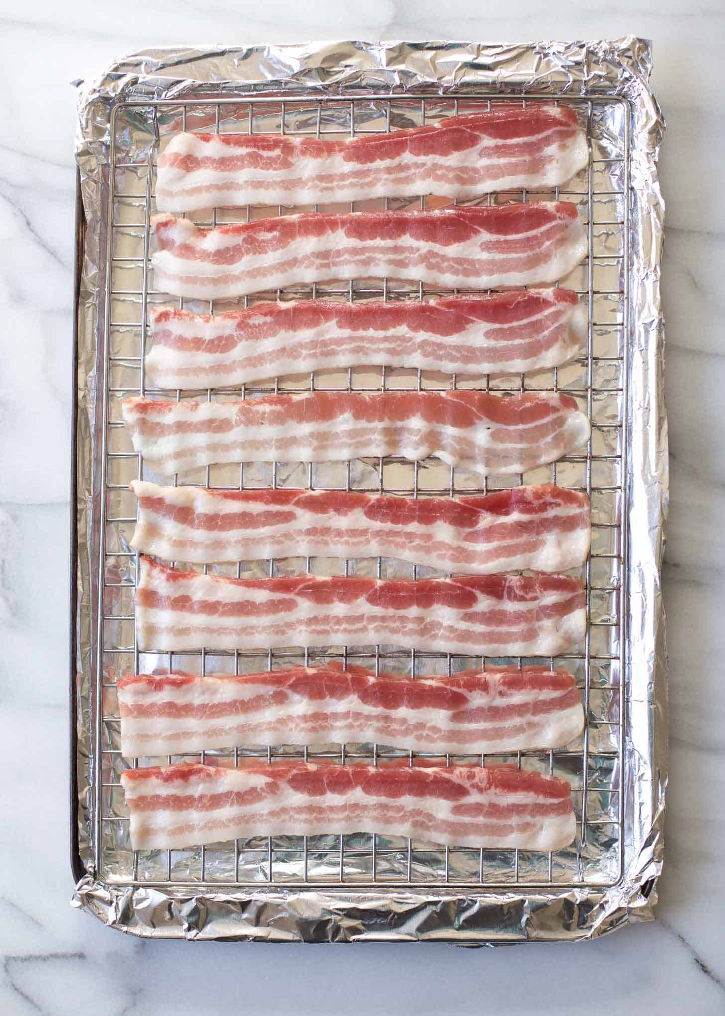 uncooked bacon on a wire rack