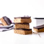 No Bake Chocolate Peanut Butter Bars stacked on a white table