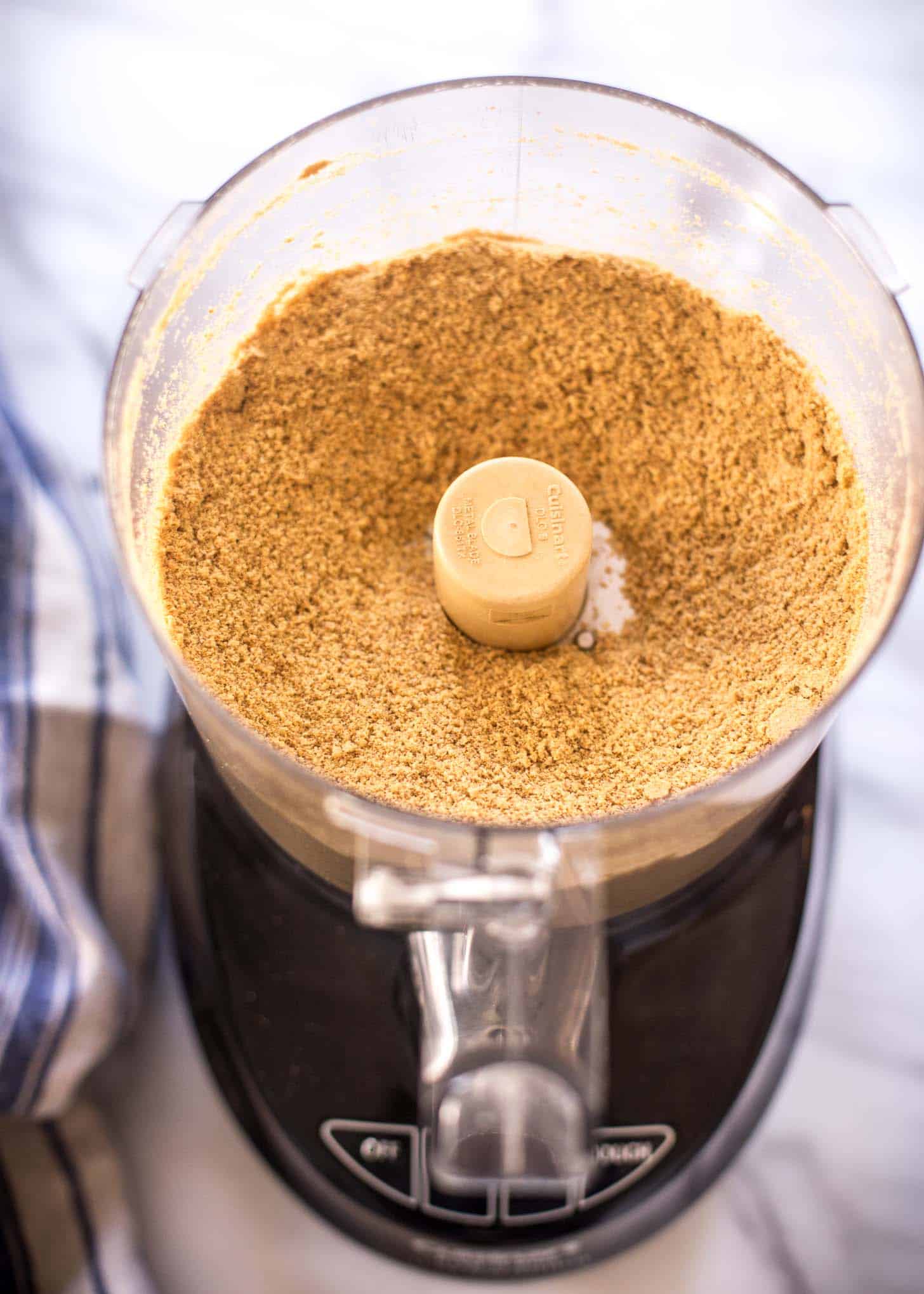 graham cracker crumbs in the bowl of a food processor