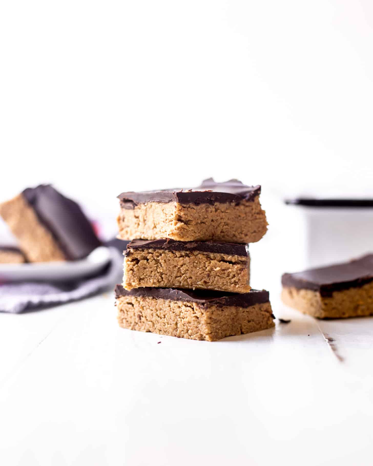 No Bake Chocolate Peanut Butter Bars, stacked on a white table