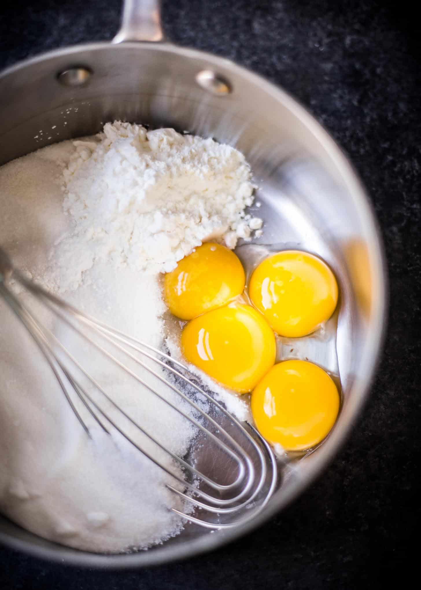 stirring ingredients in a saucepan with a whisk