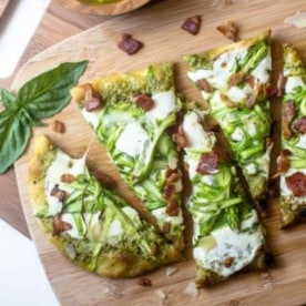 pesto flatbread sliced on a wooden cutting board