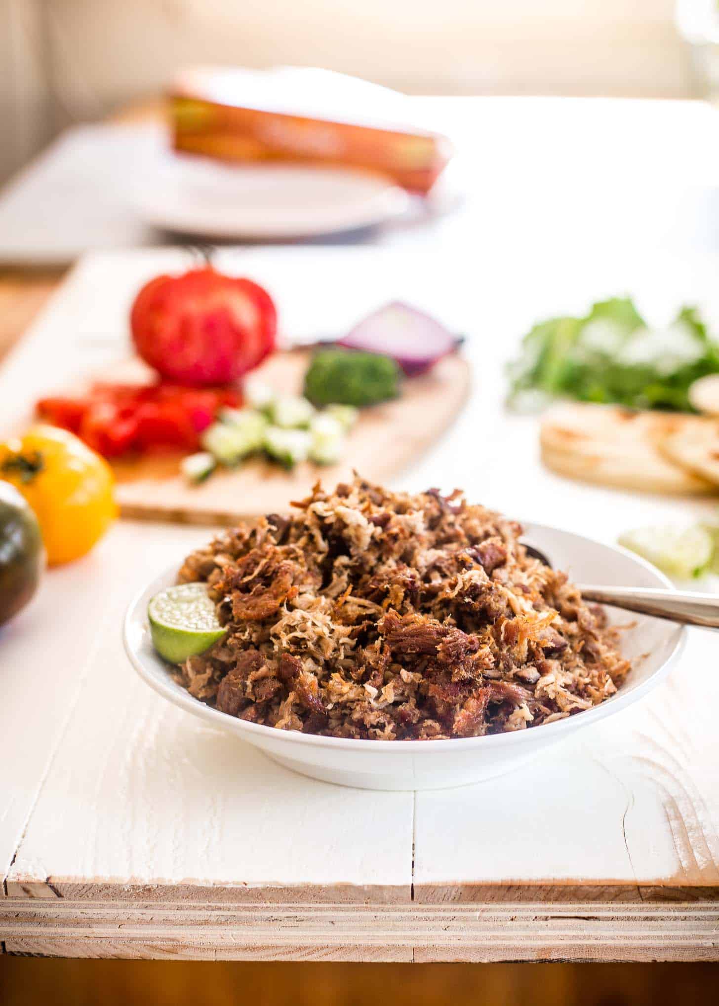 crispy pork in a white bowl with a spoon