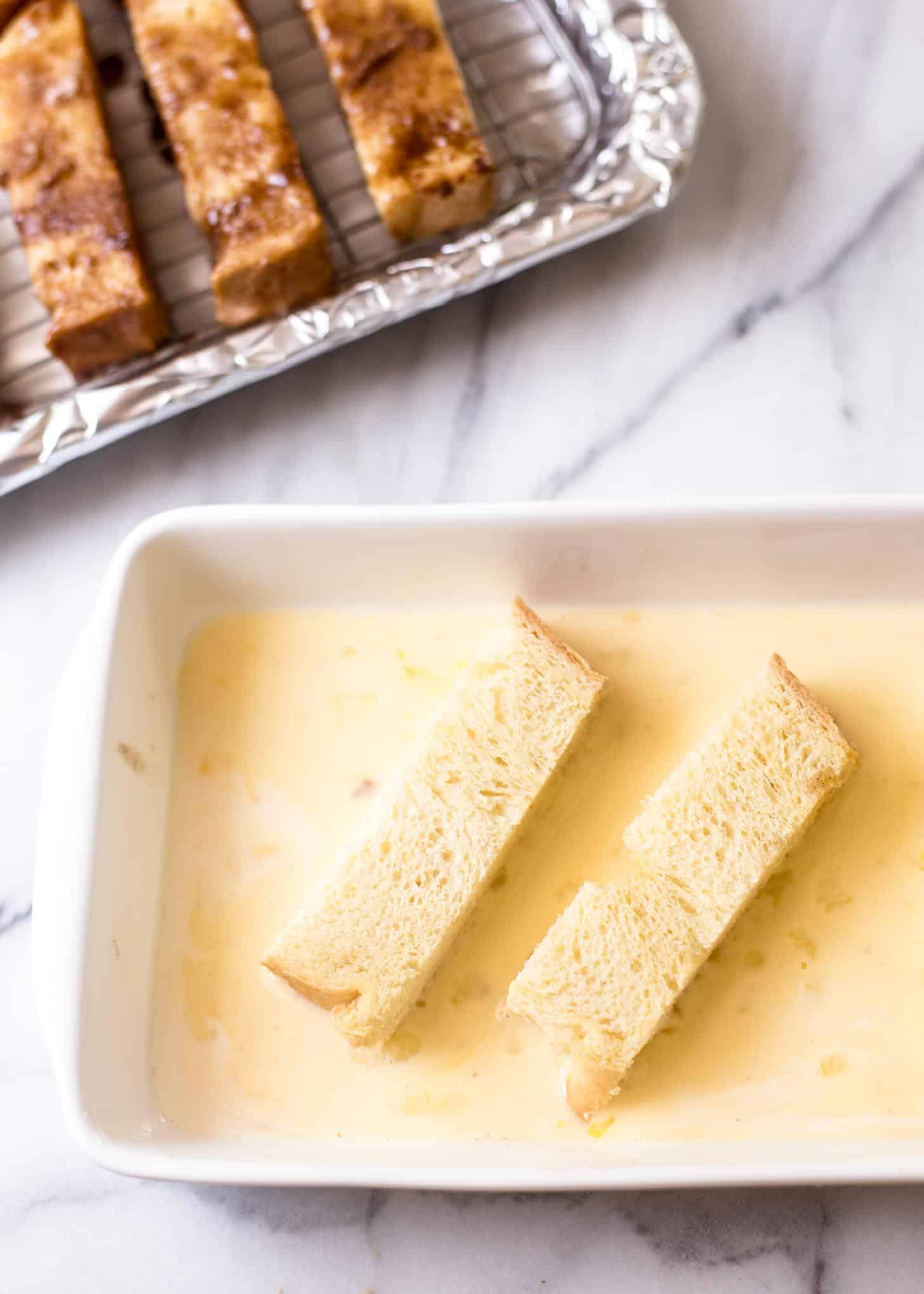 dipping toast slices into egg mixture