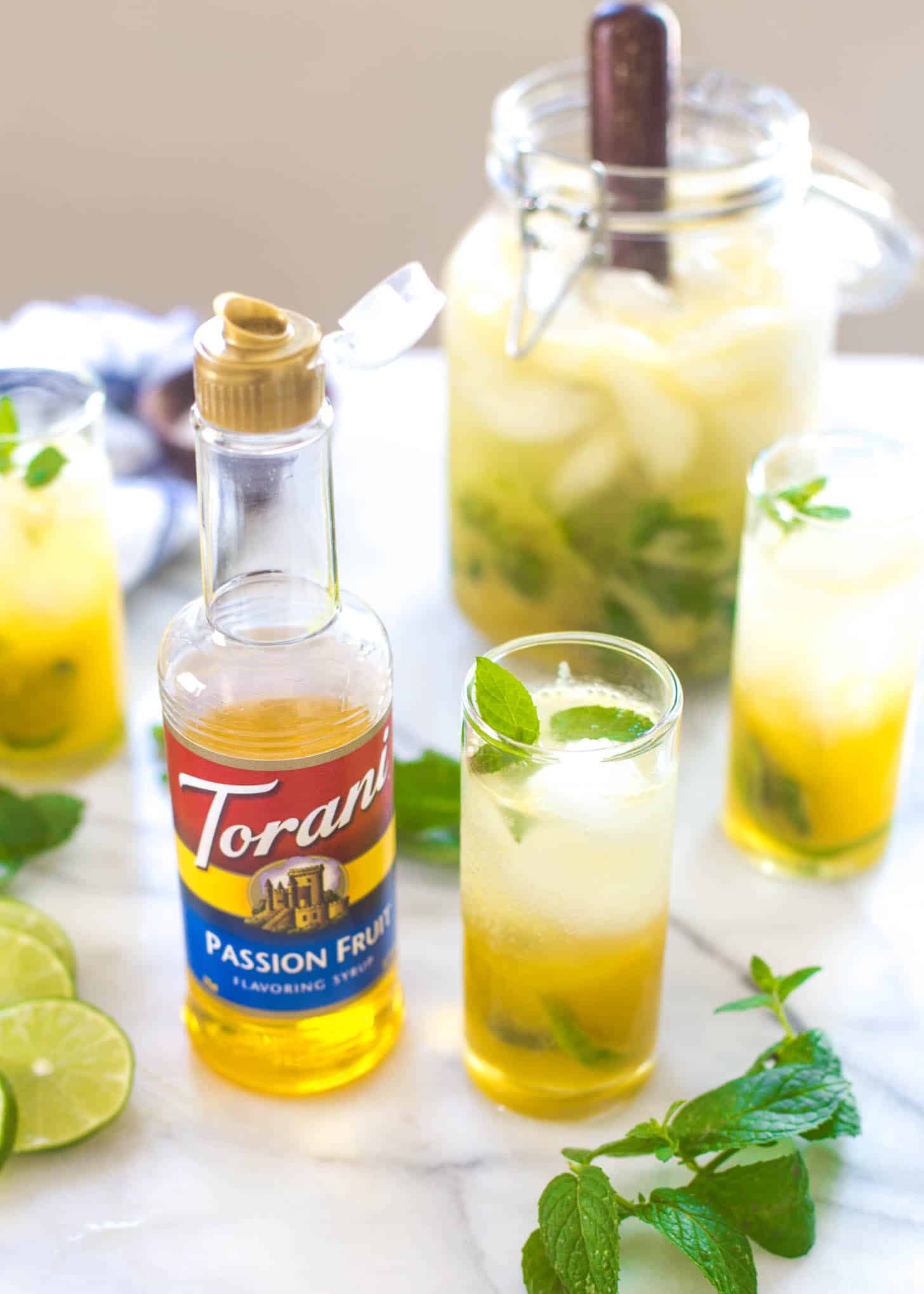 Passion Fruit Mojitos next to a bottle of passion fruit syrup