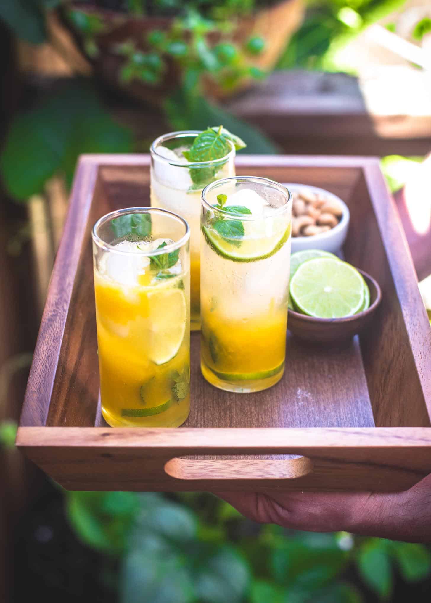 Passion Fruit Mojitos in clear glasses on a wooden tray