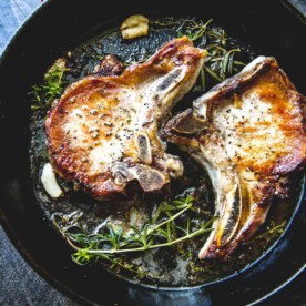 cooking Herb Marinated Pork Chops in a cast iron skillet