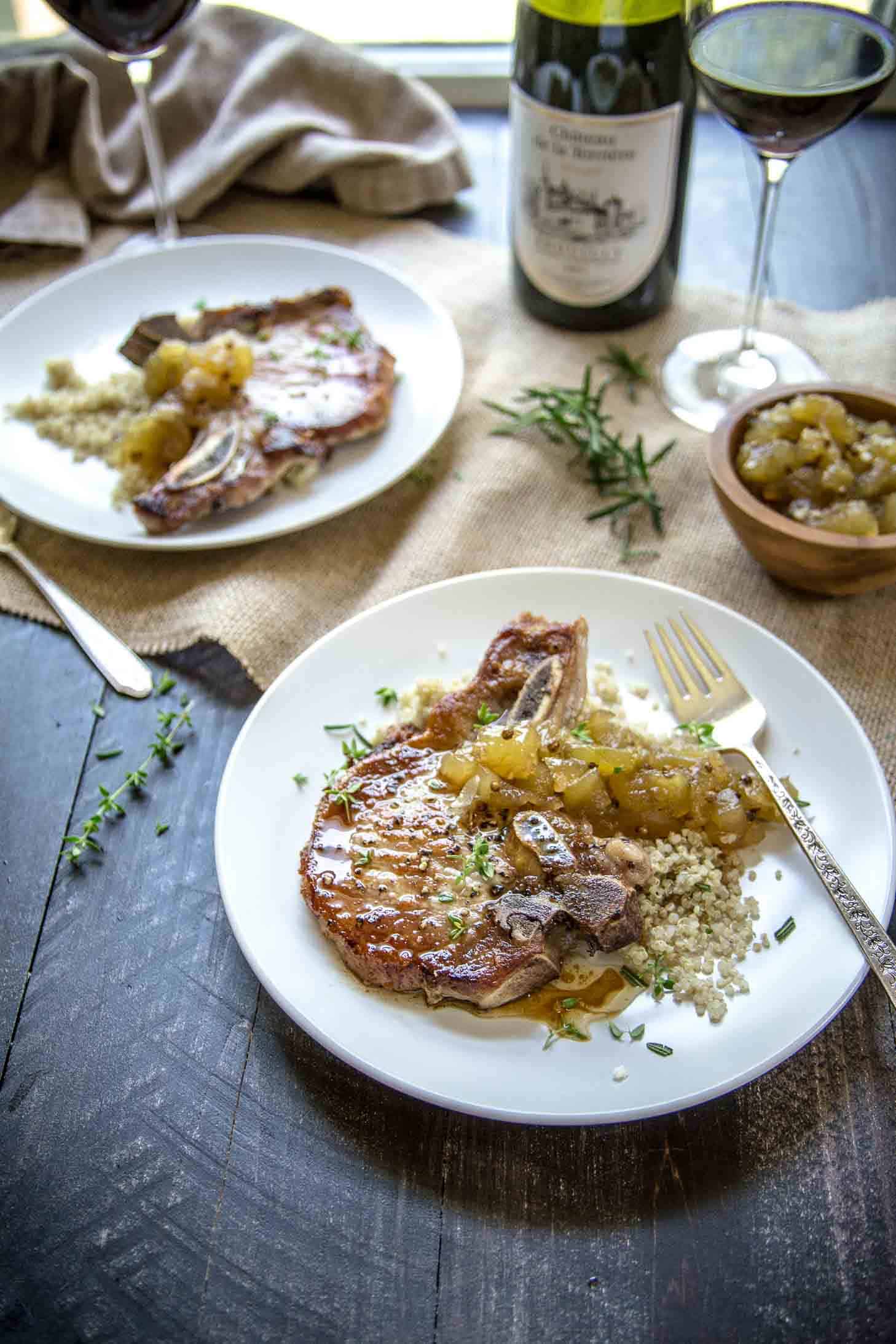 Herb Marinated Pork Chops with Apple Chutney on white plates on a wooden table