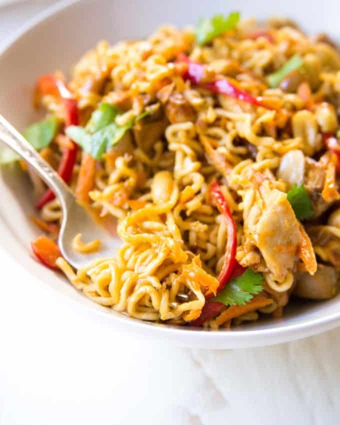 Thai Chicken Peanut Noodles in a white bowl with a fork