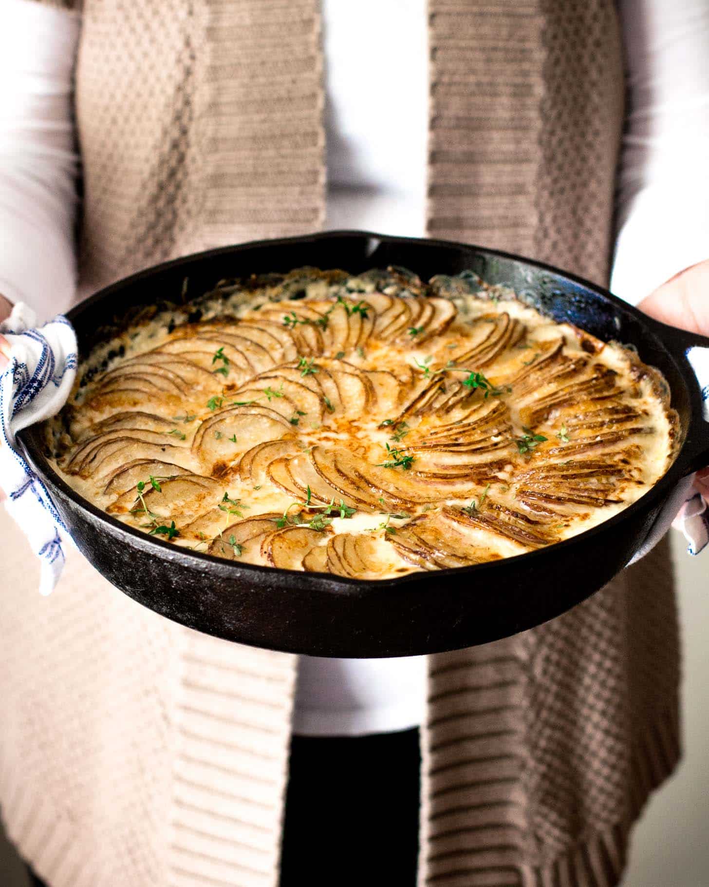 Creamy Au Gratin Potatoes with Kale and Gruyere in a cast iron skillet