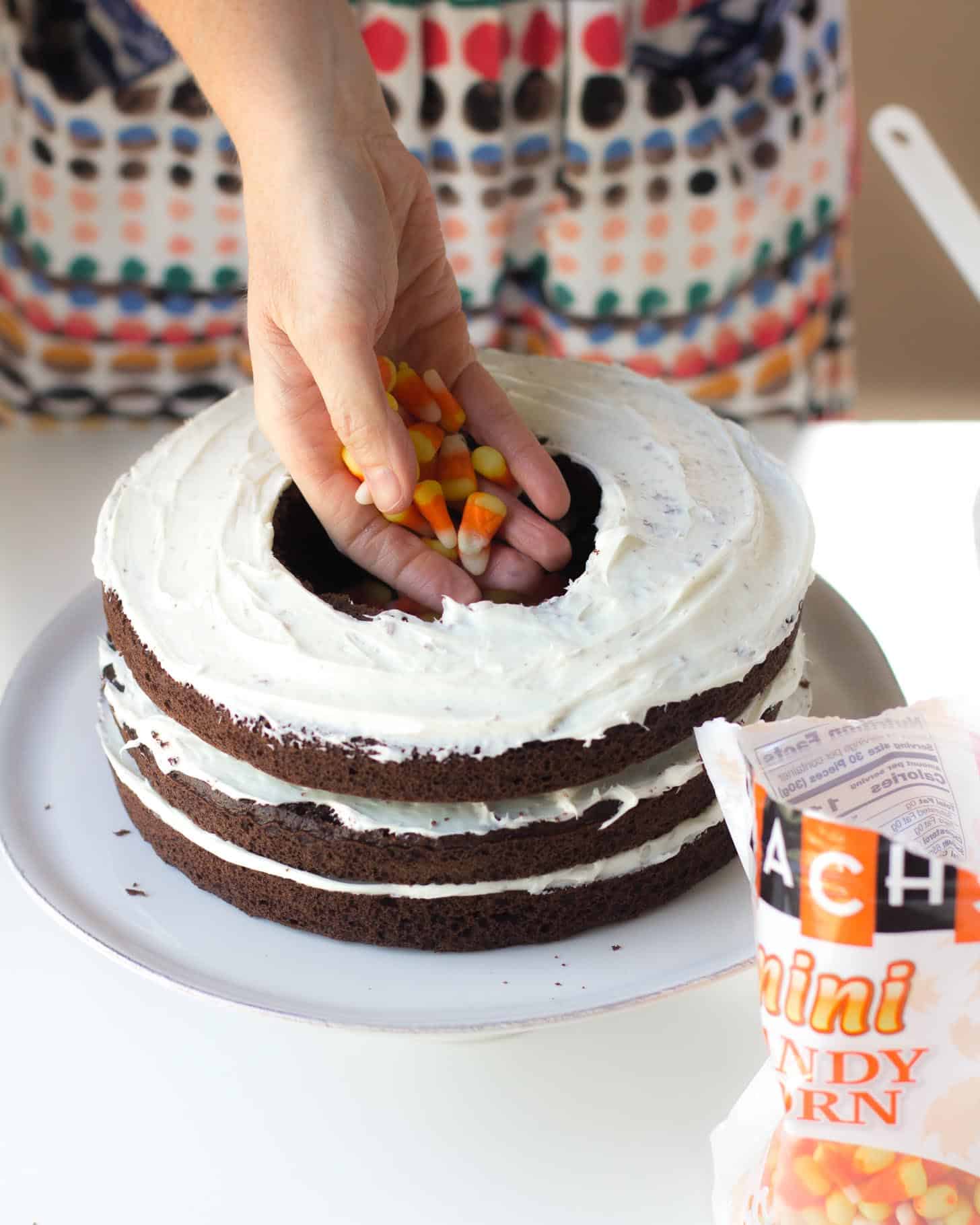 adding candy corn to the center of the pinata cake