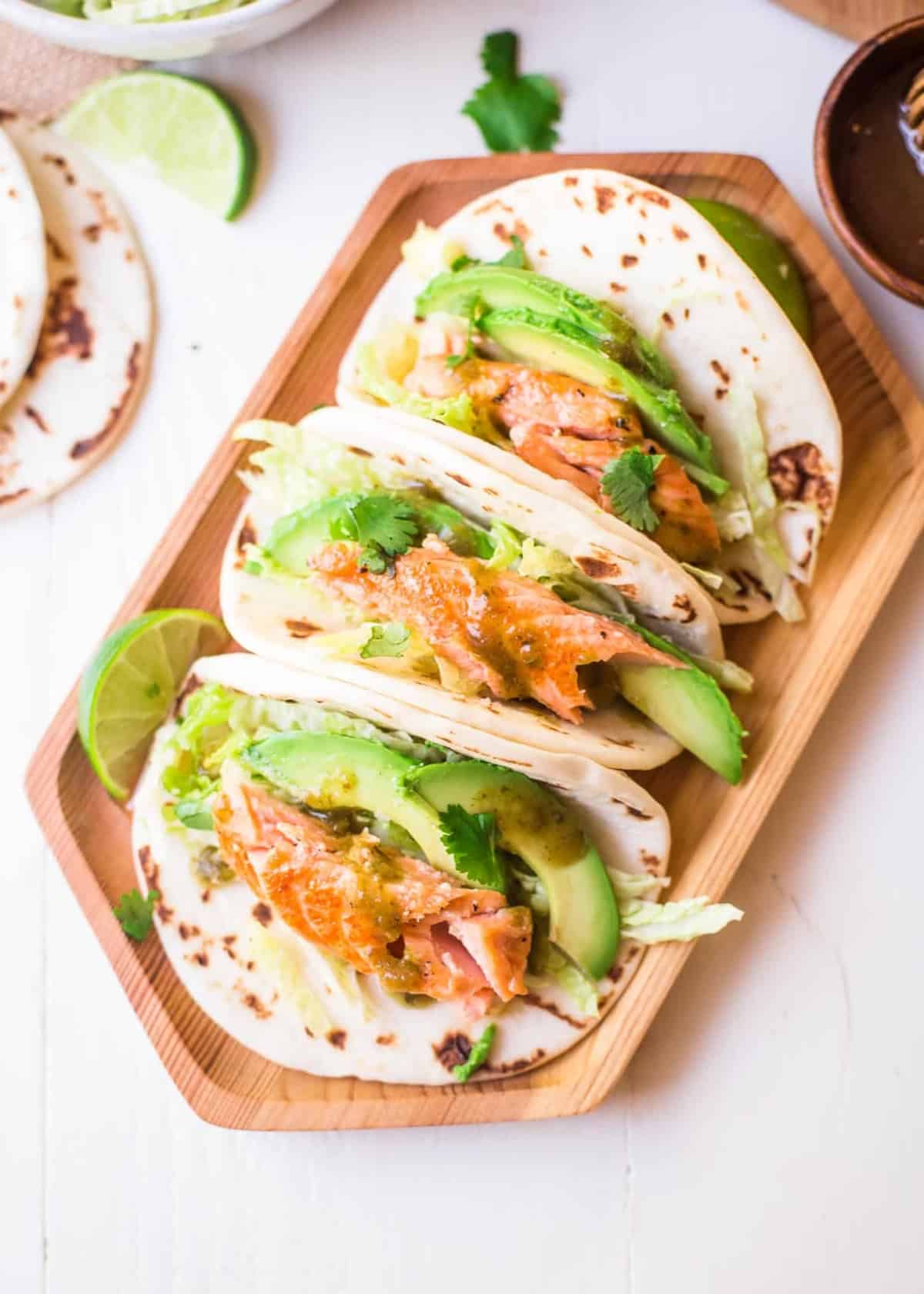 Honey Lime Salmon Tacos on a wooden tray