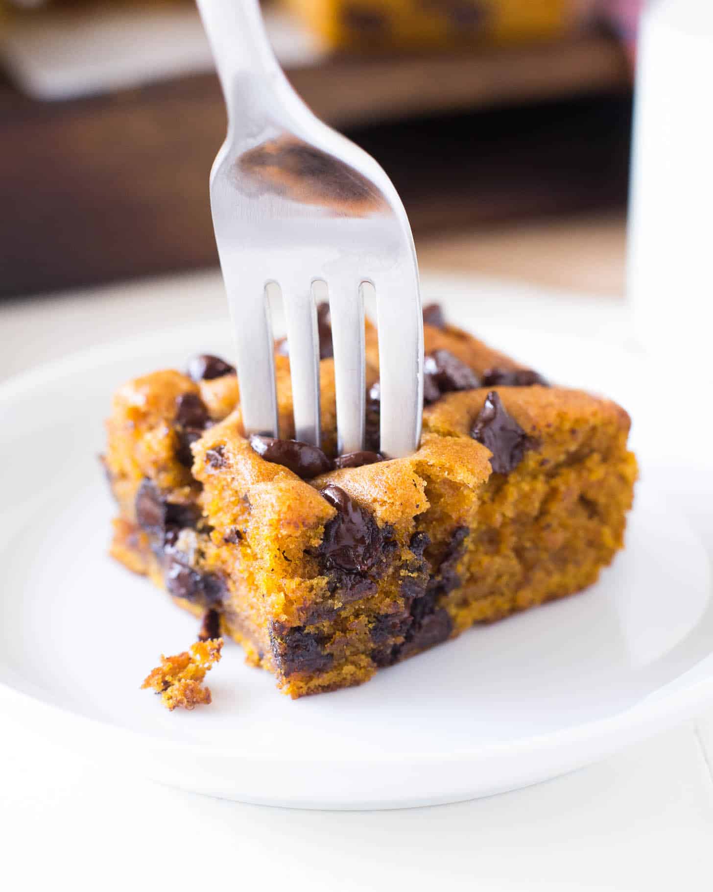 a piece of pumpkin snack cake on a white plate with a fork