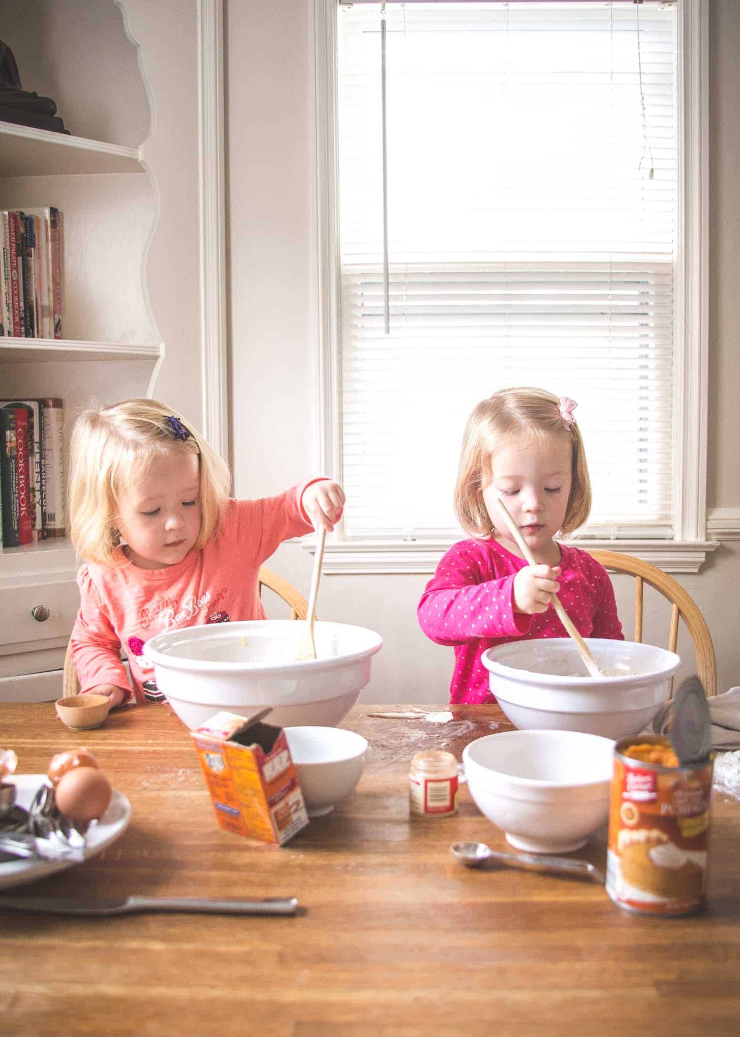 Molly and Clara stirring in big white bowls