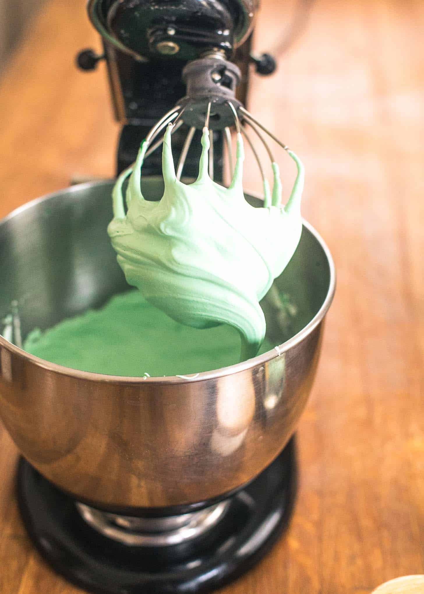 mixing green into meringue in a stand mixer