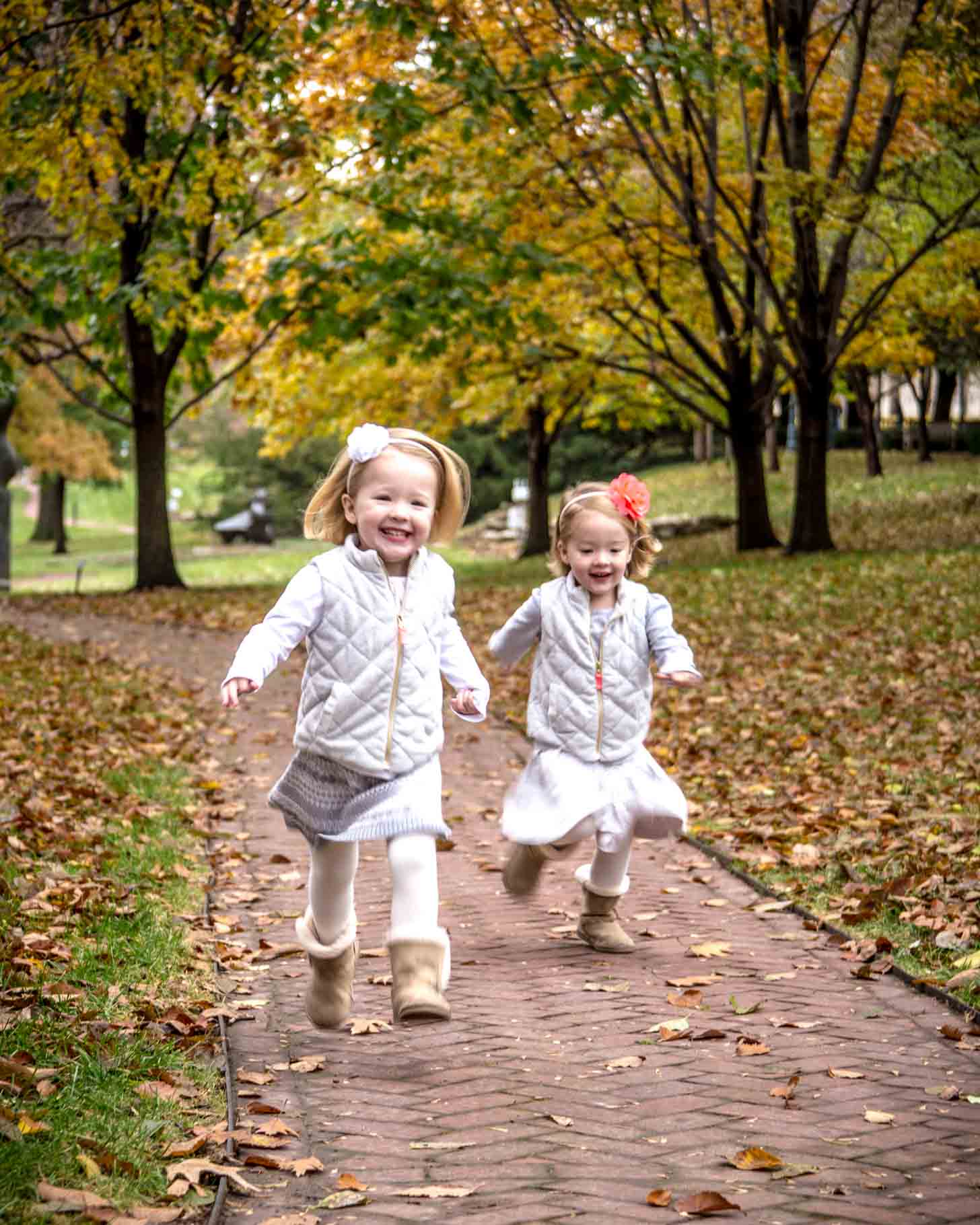Molly and Clara running down sidewalk in fall