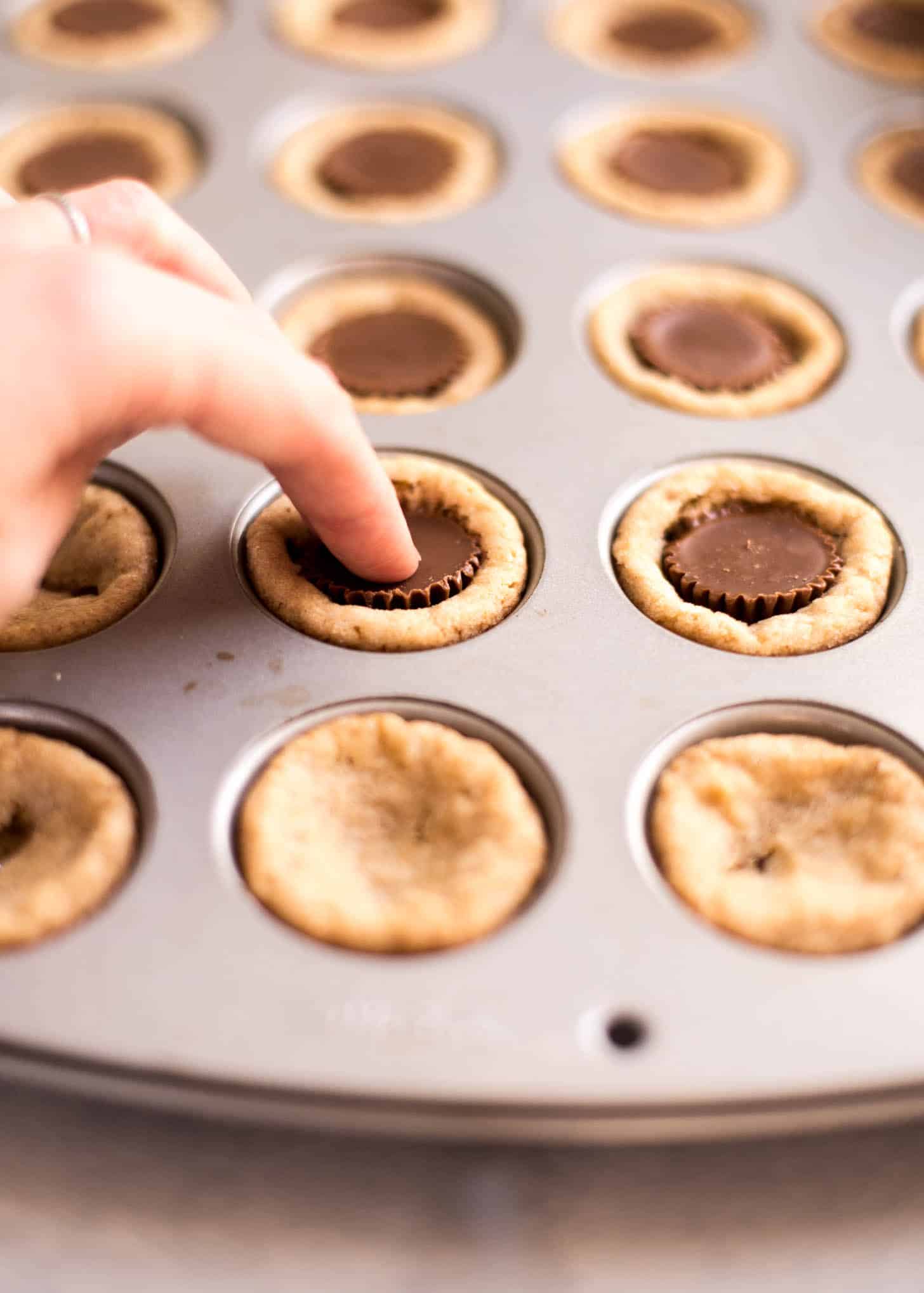 pressing a peanut butter cup into dough