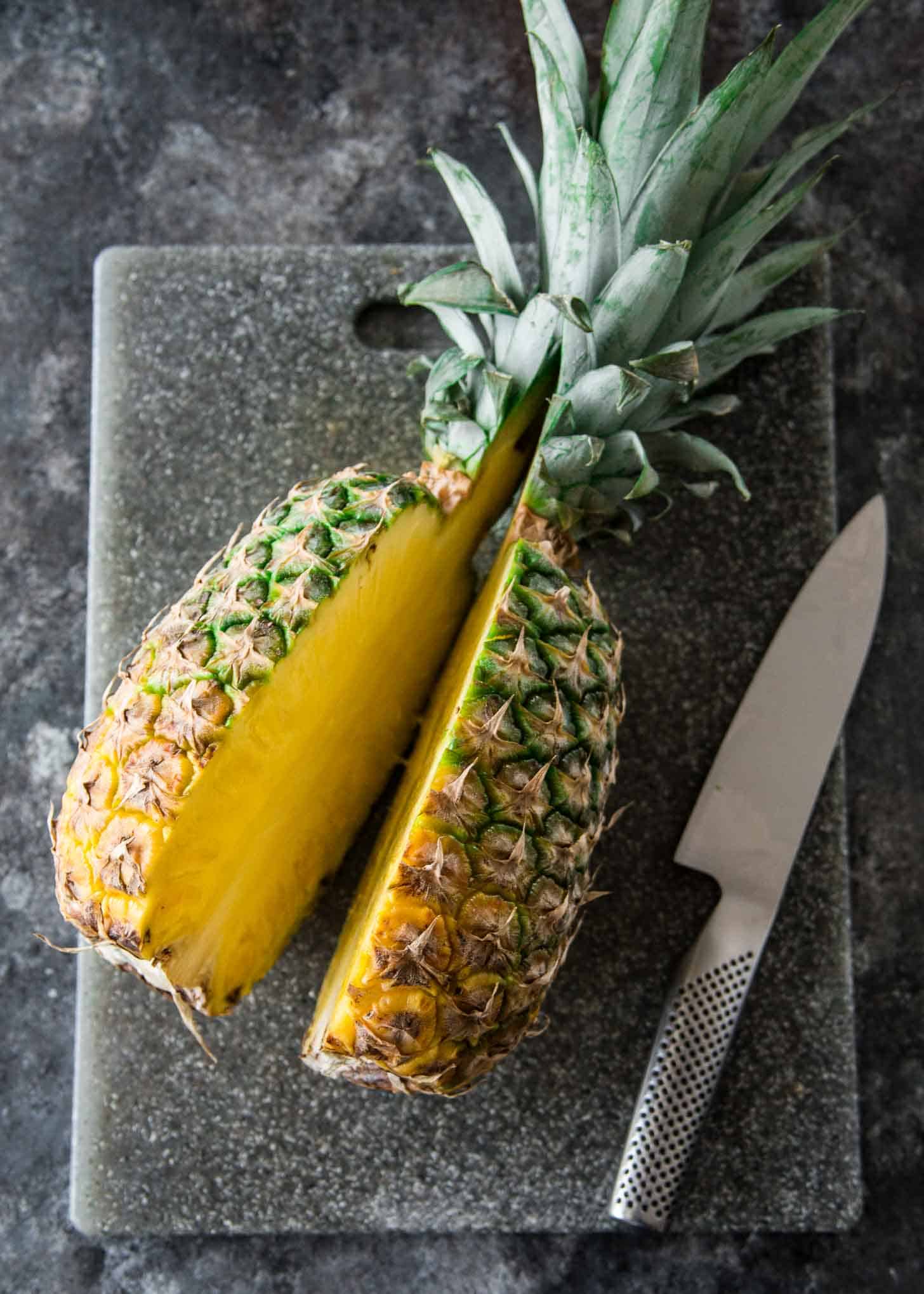 a pineapple sliced in half on a grey countertop