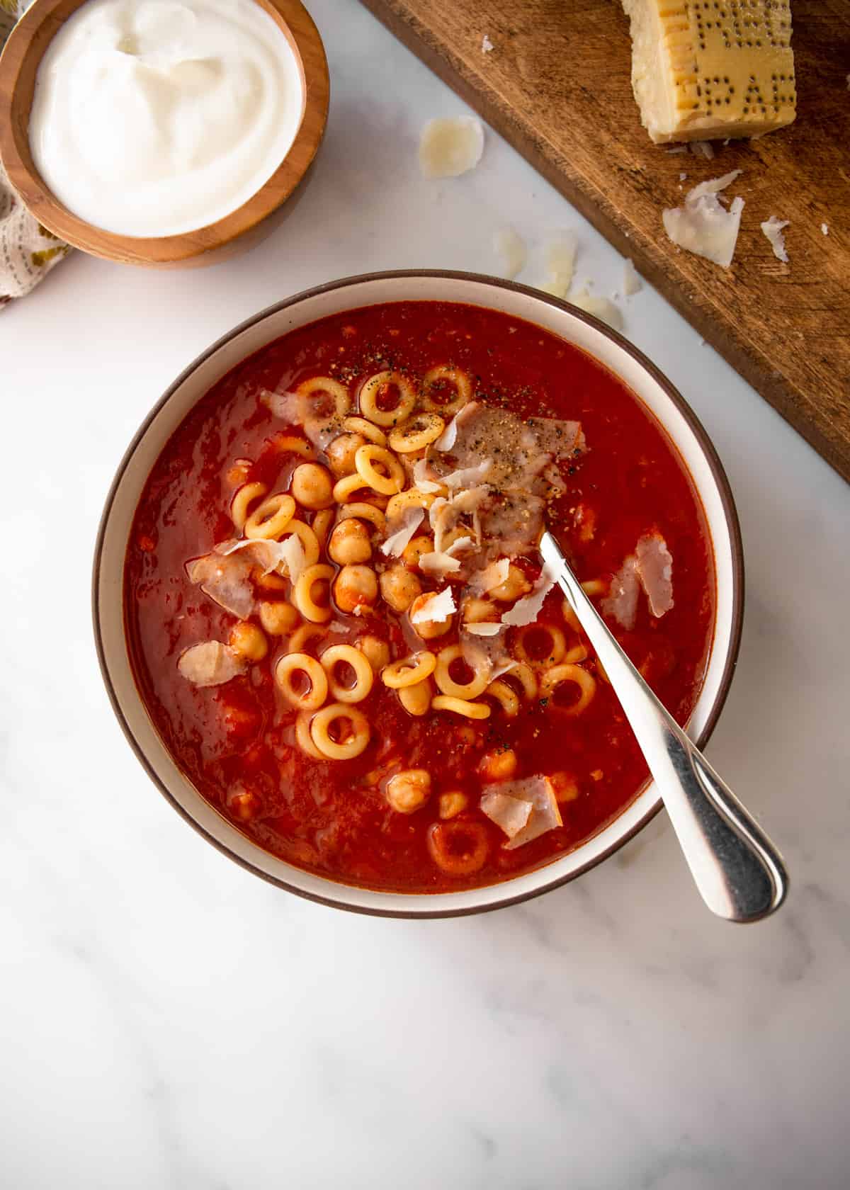 overhead image of tomato chickpea soup with pasta and parmesan