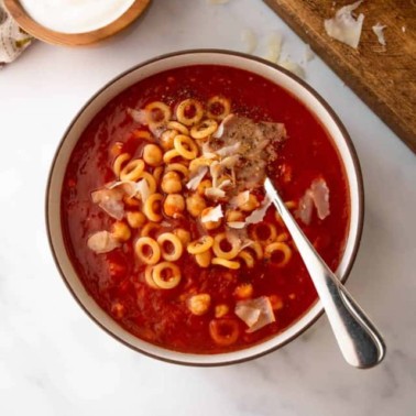 overhead image of tomato chickpea soup with pasta and parmesan