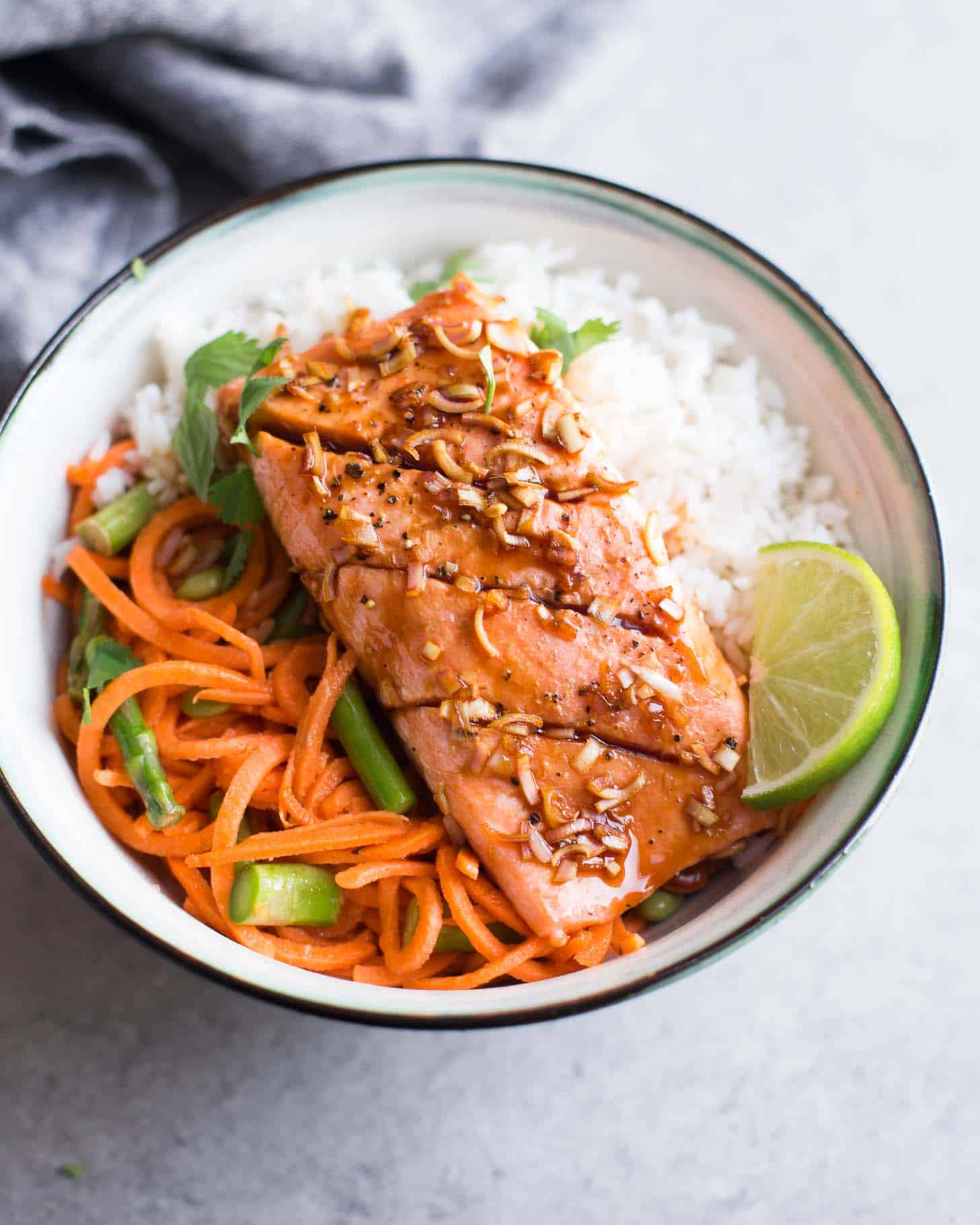 overhead image of salmon and rice in a white bowl