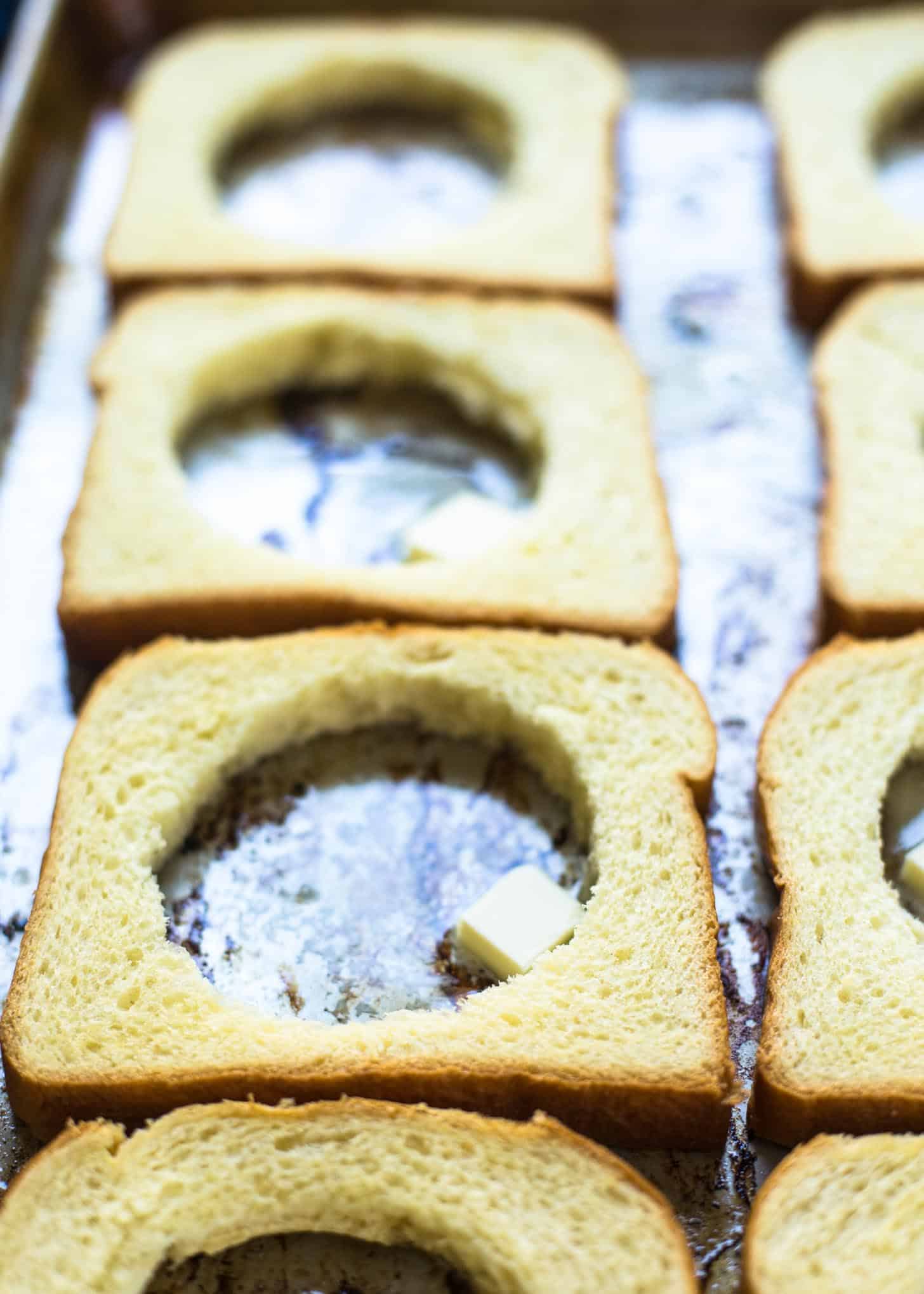 making holes in bread for egg in a hole