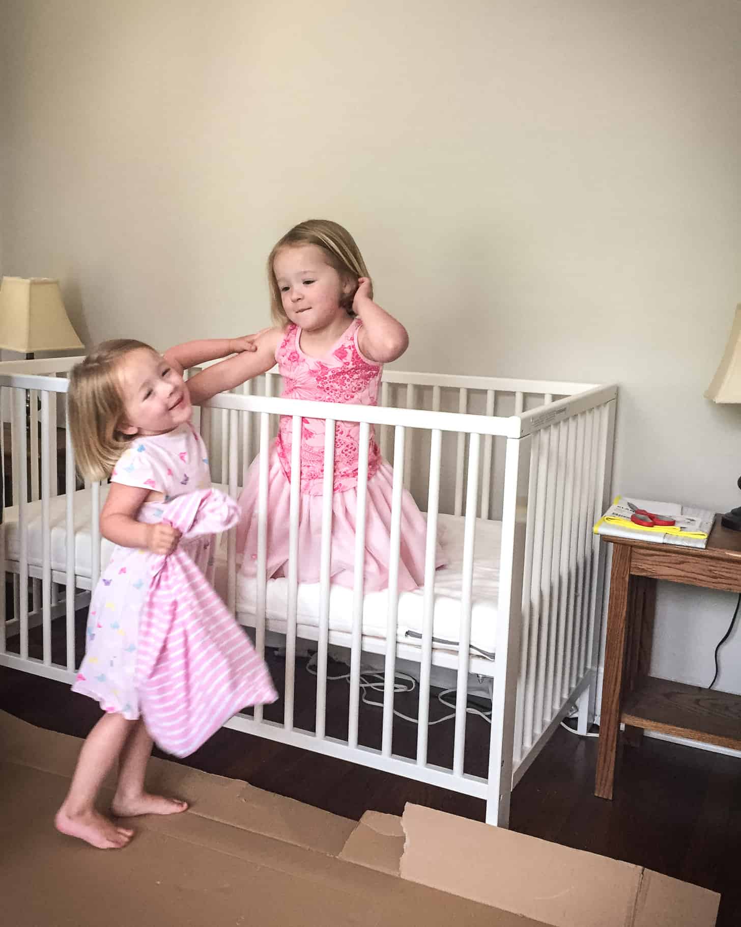 Molly and Clara playing in the baby's crib