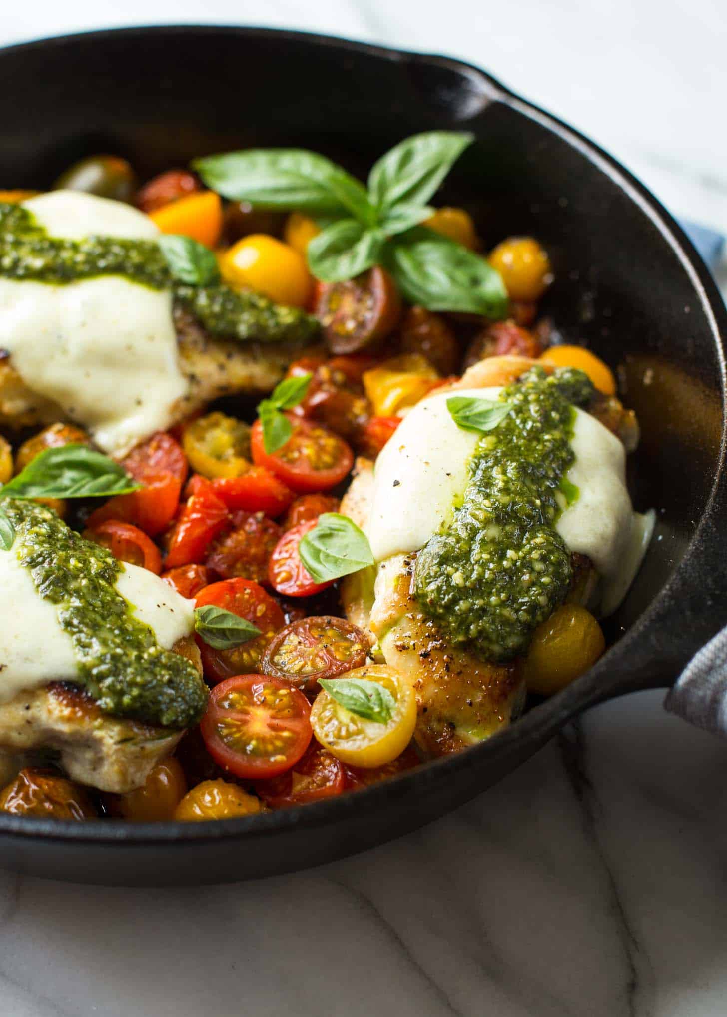 Caprese Chicken with Pesto in a skillet