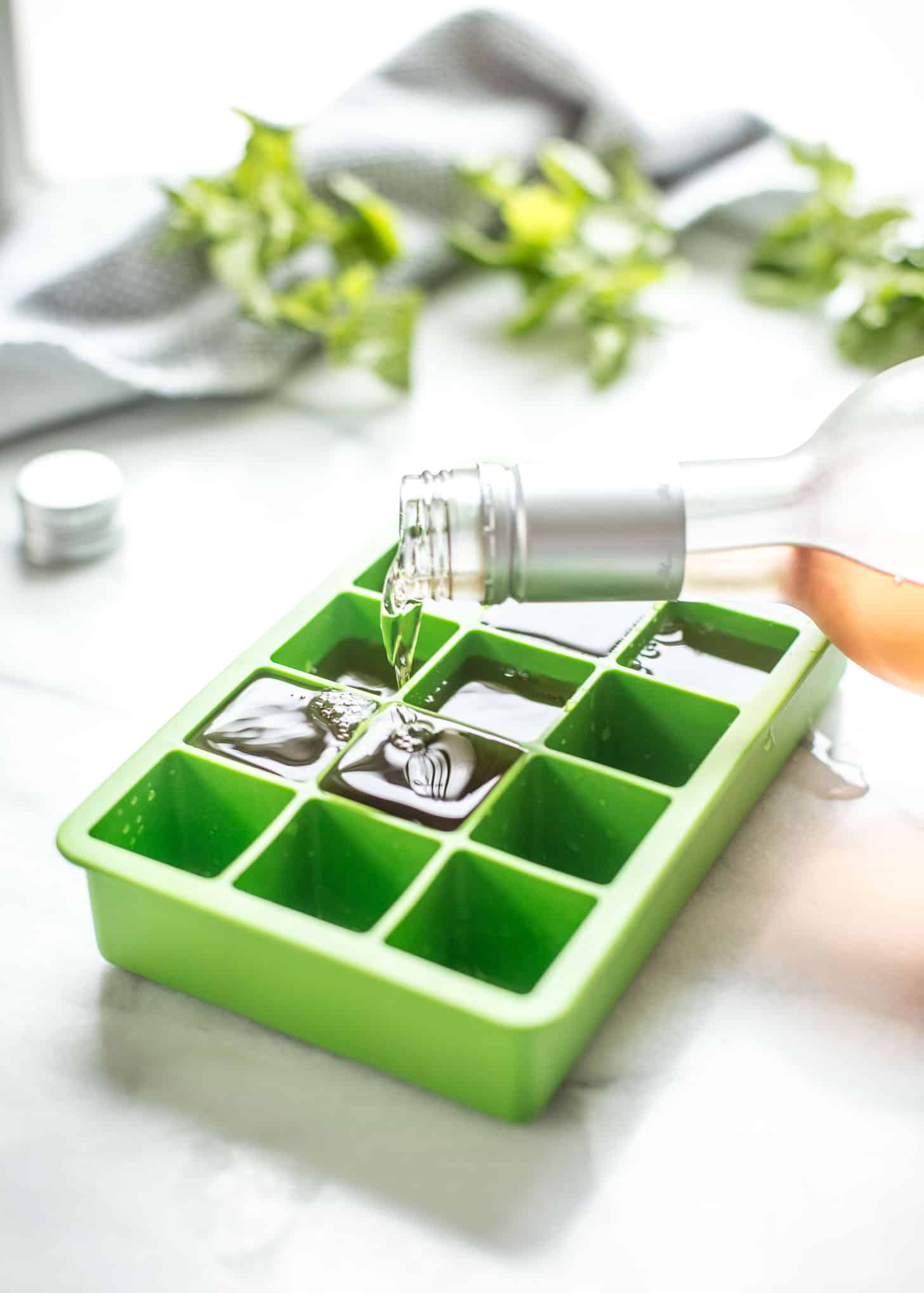 pouring white wine into ice cube trays