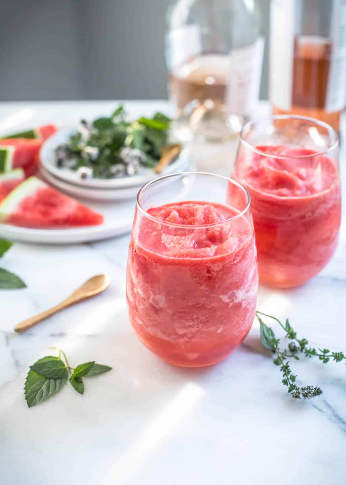 two glasses of watermelon frose on a white table