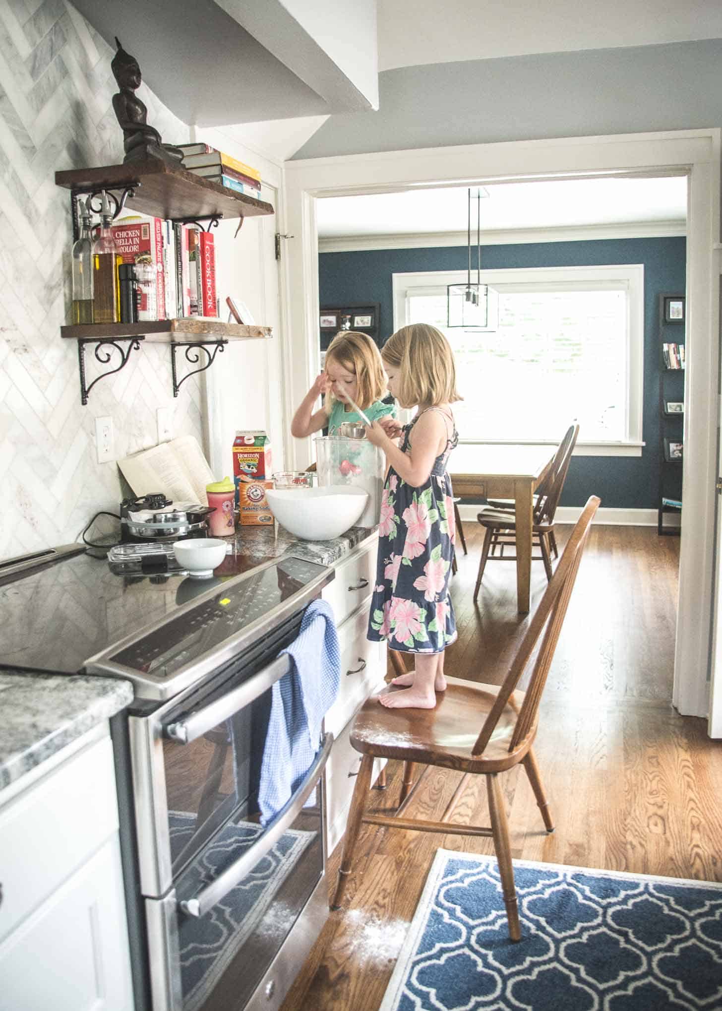 two little girls on chairs helping with baking