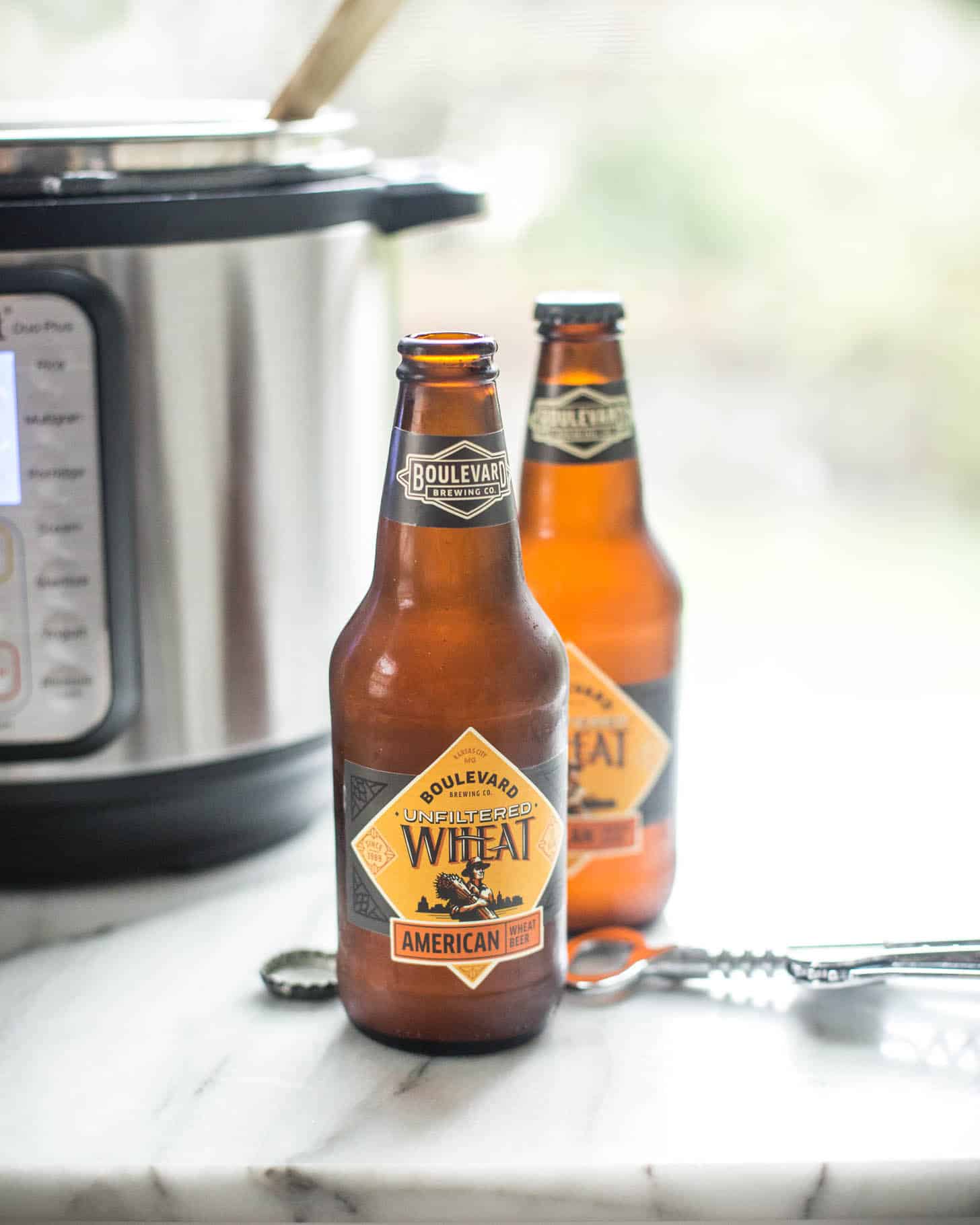 two bottles of beer next to an instant pot