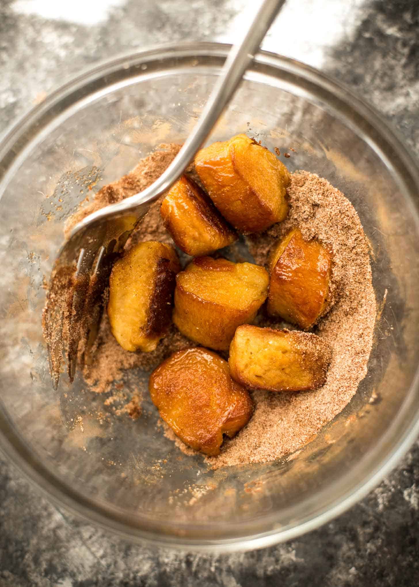 rolling pretzel bites in cinnamon sugar mixture