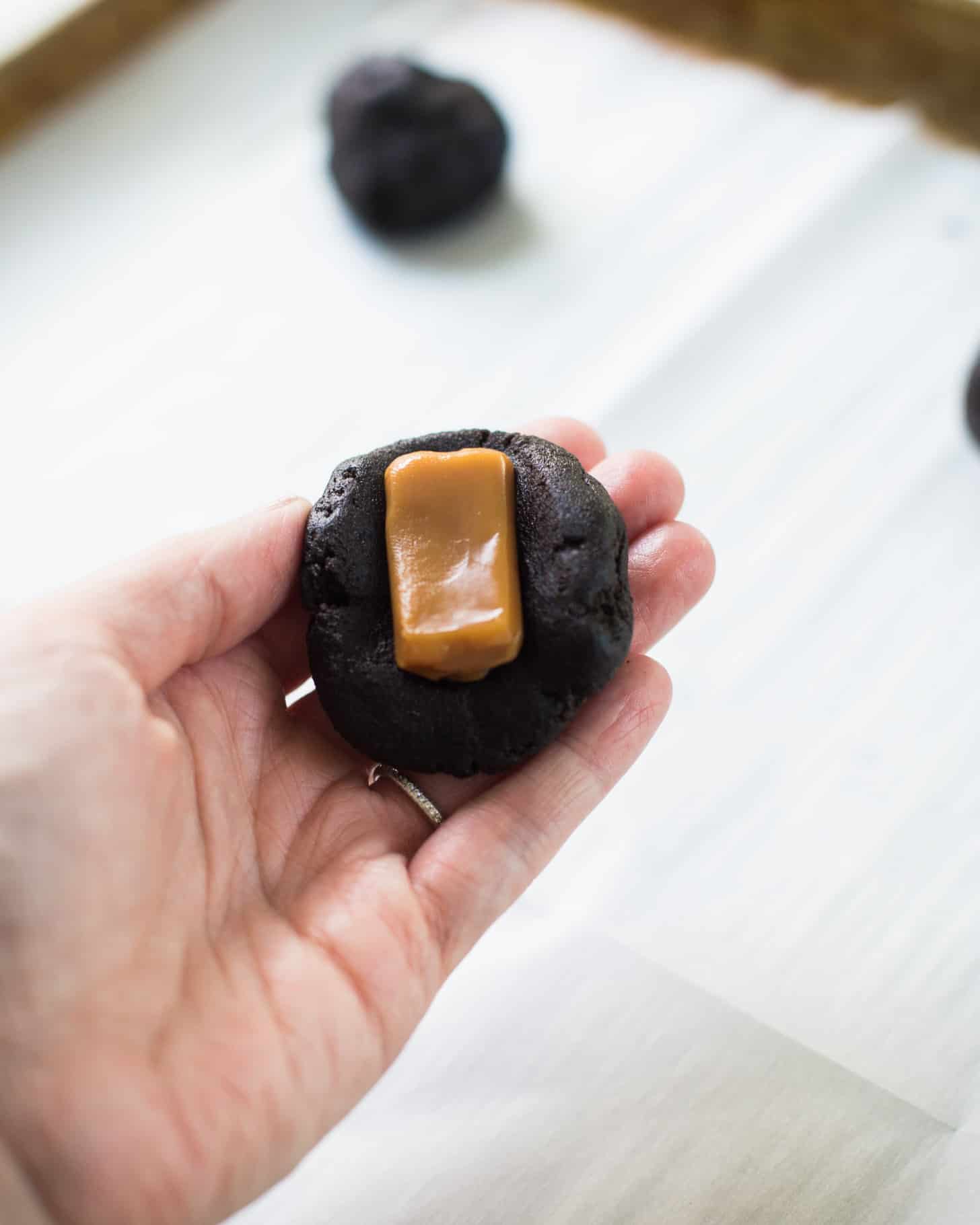 adding a caramel to the cookie dough