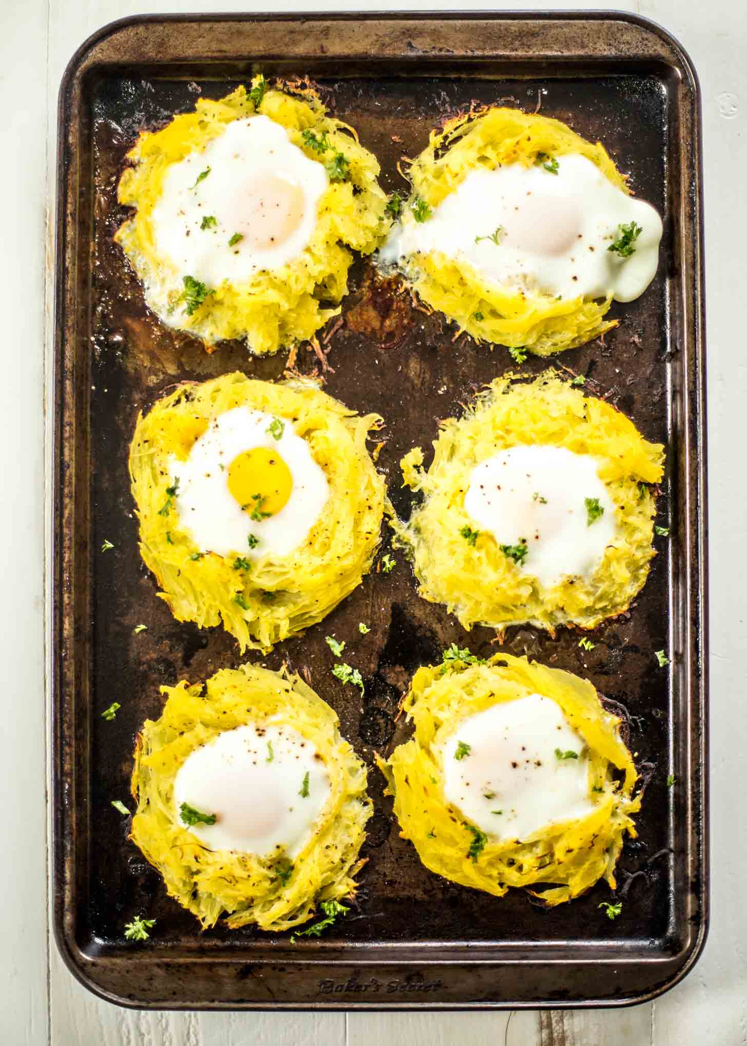 overhead image of cooked Spaghetti Squash Egg Nests on a sheet pan