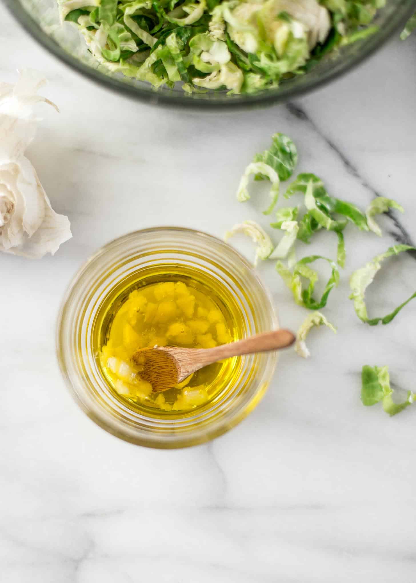 overhead image of oil and garlic in a clear jar