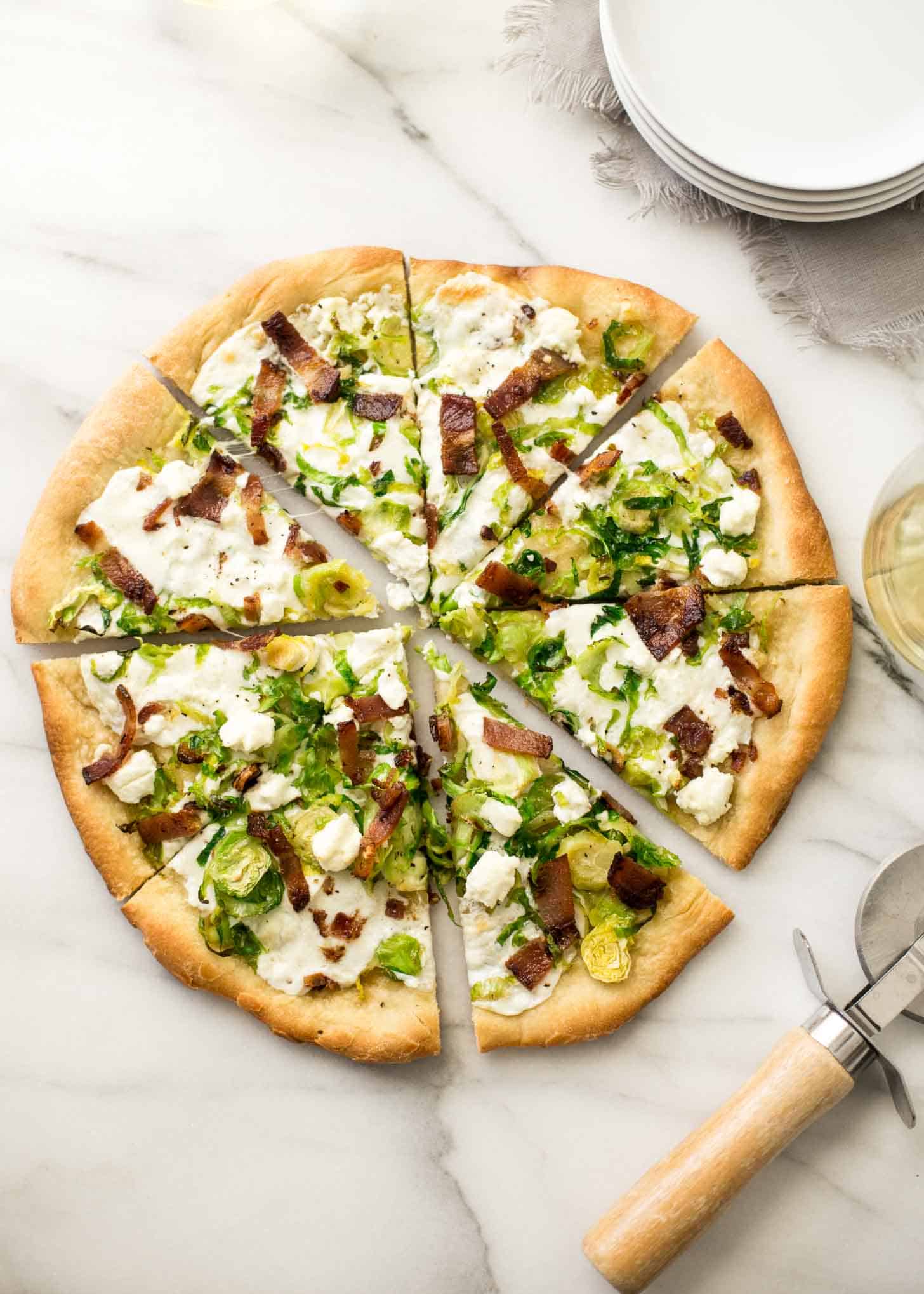 overhead image of sliced Brussels Sprouts, Bacon, and Goat Cheese Pizza