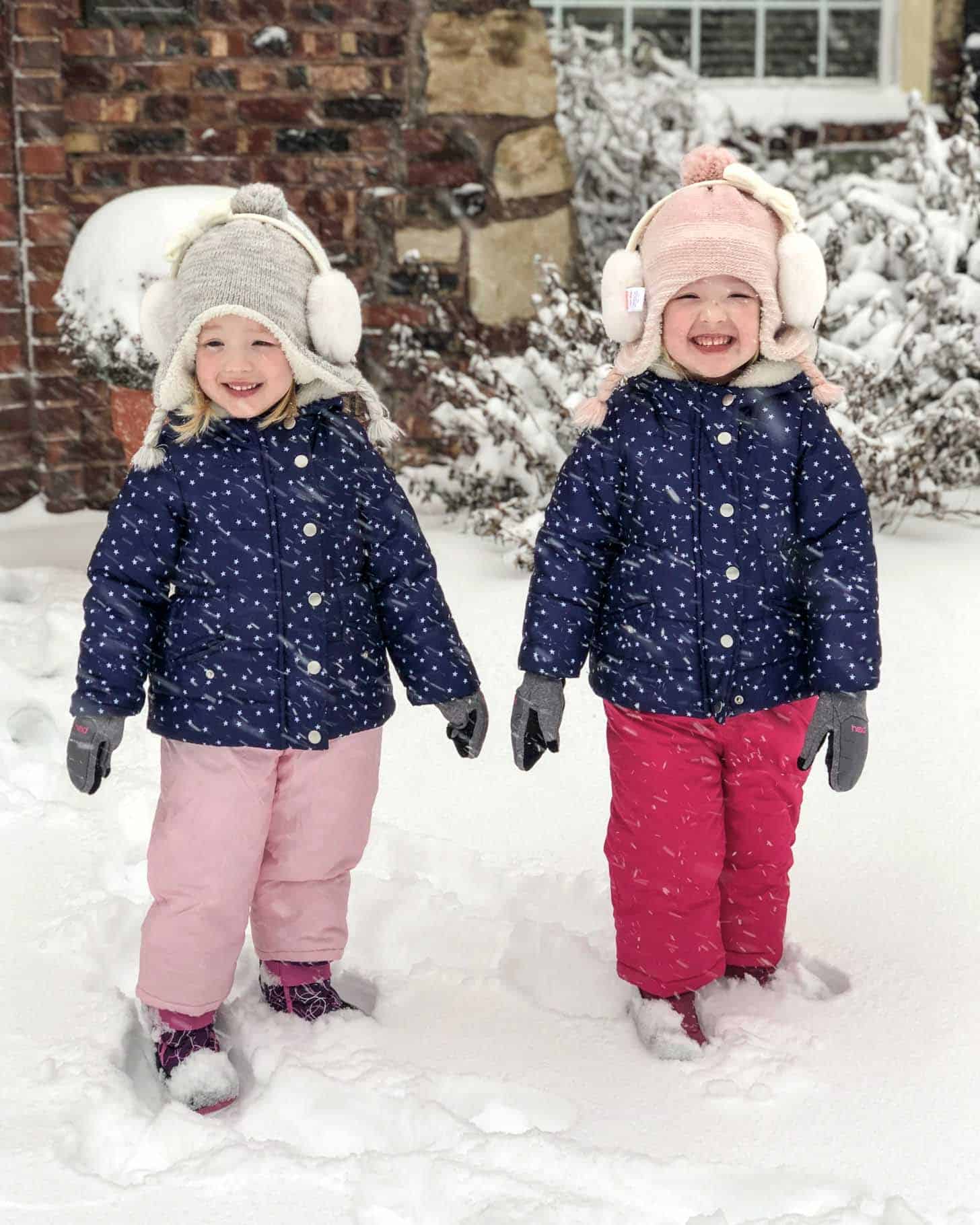 two little girls in snow gear outside
