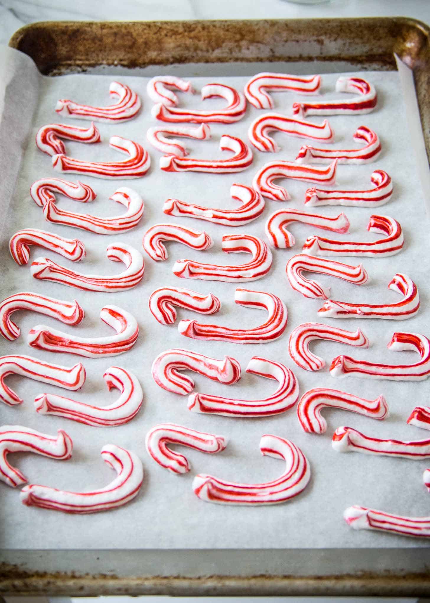 Candy Cane Meringues on a parchment lined sheet pan