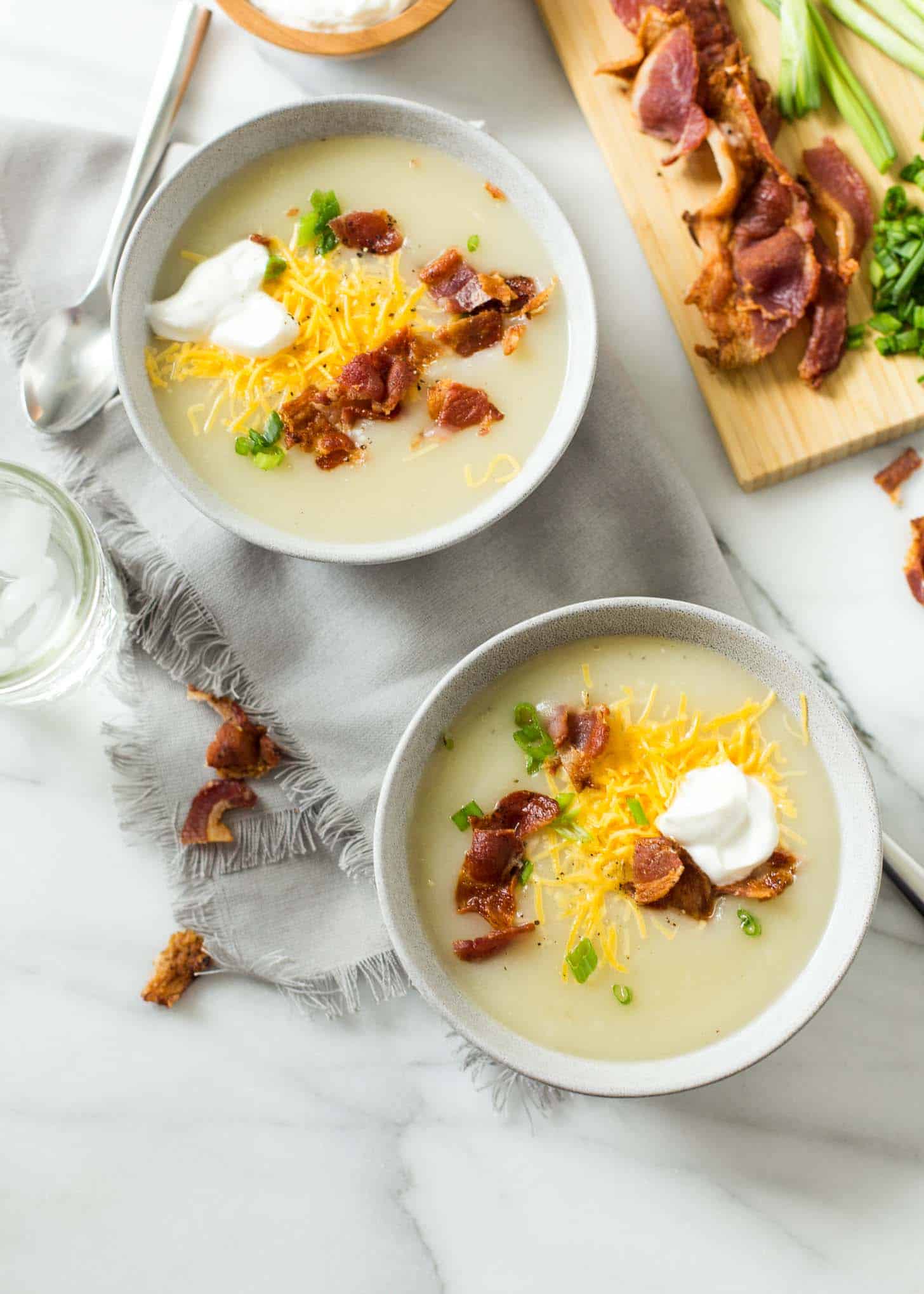 bowls of Baked Potato Soup on a white table