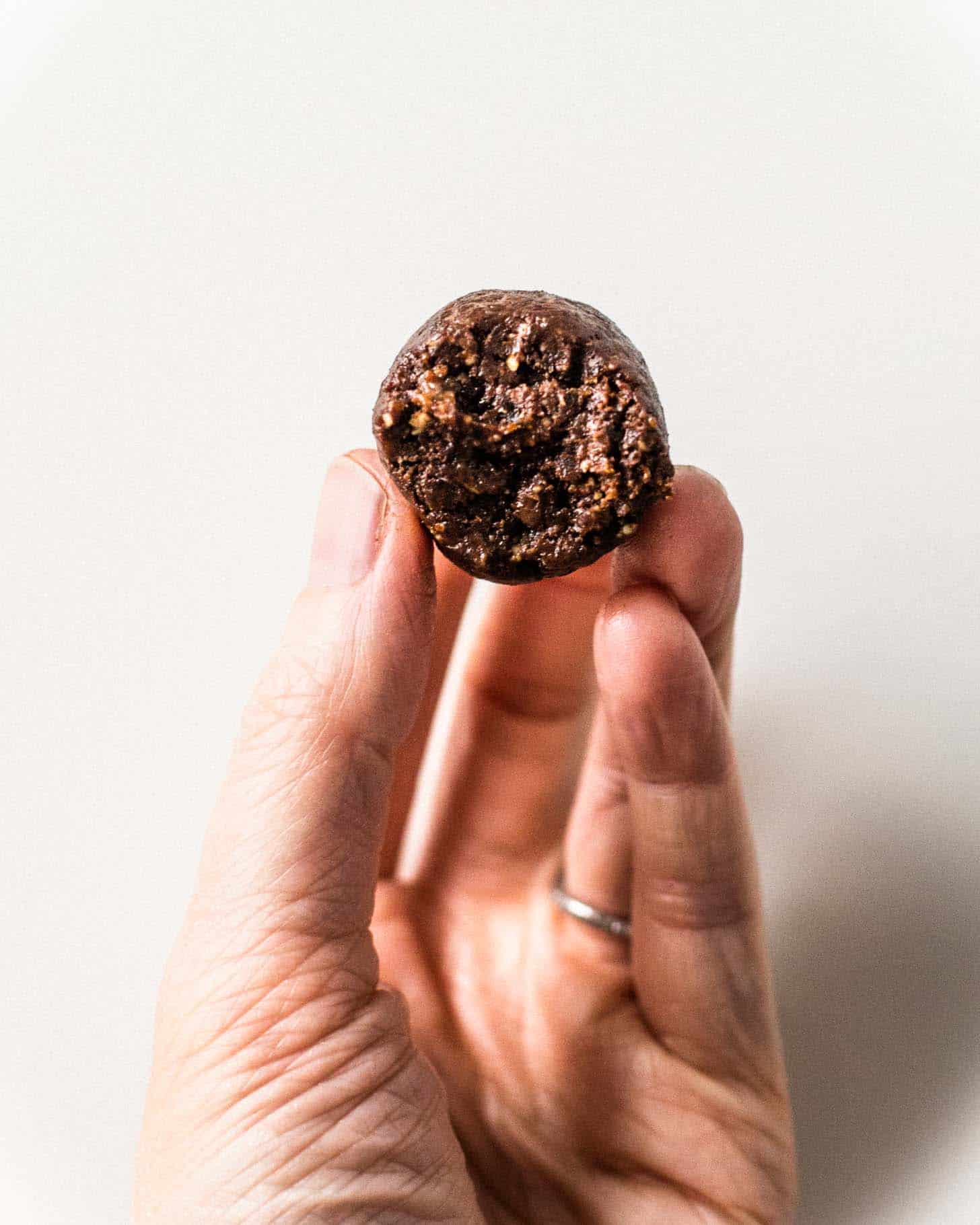 a hand holding a chocolate energy bite