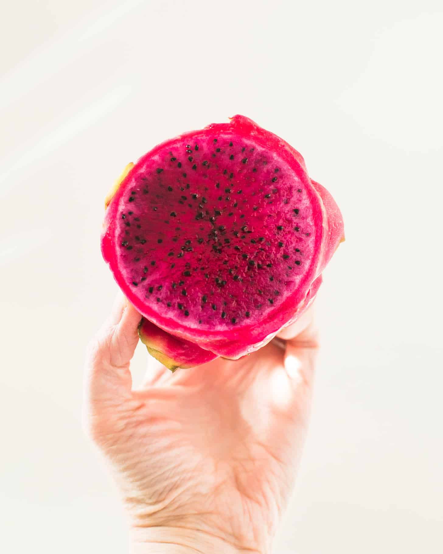 a hand holding a Dragon Fruit