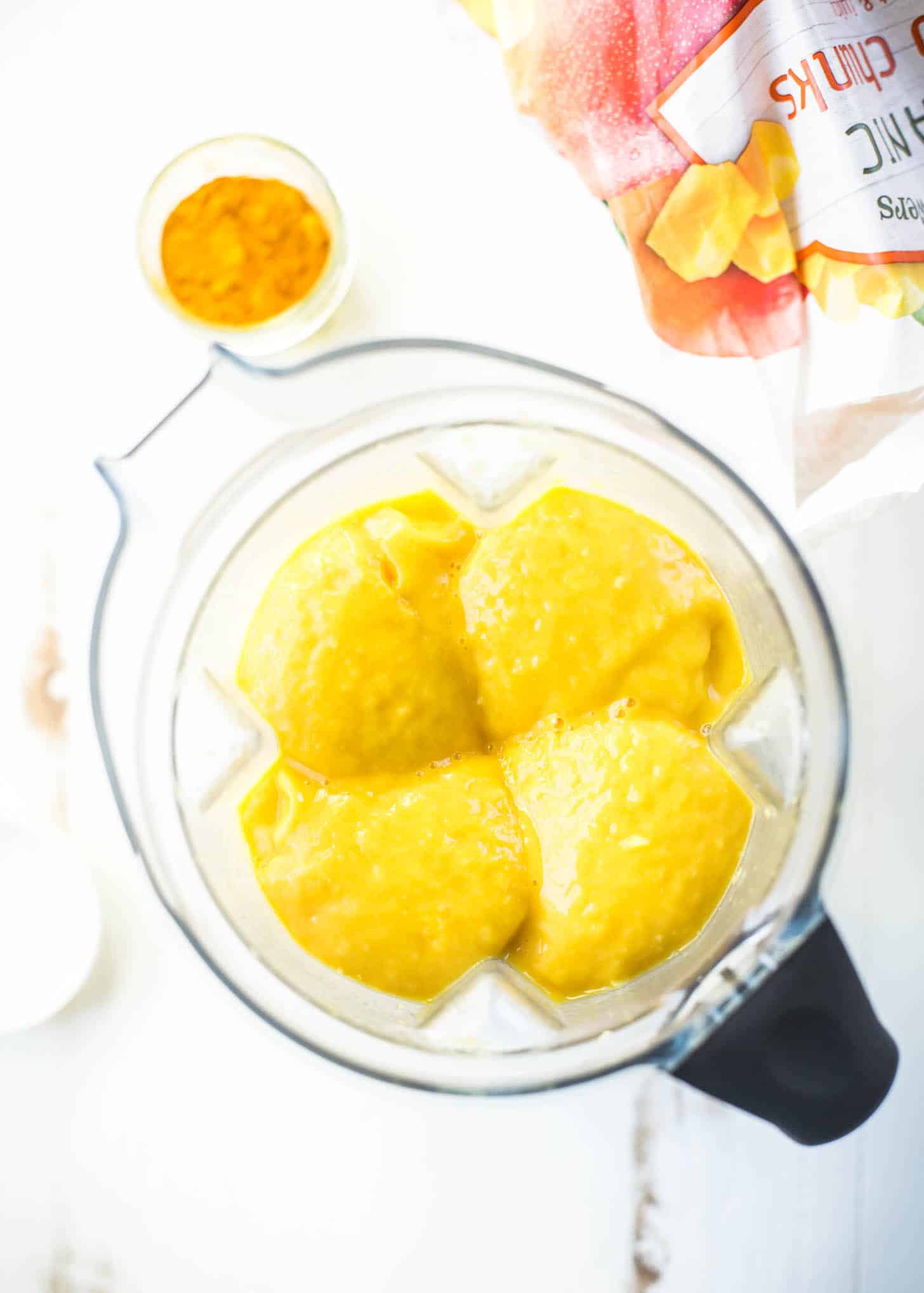 overhead image of frozen mango in a blender