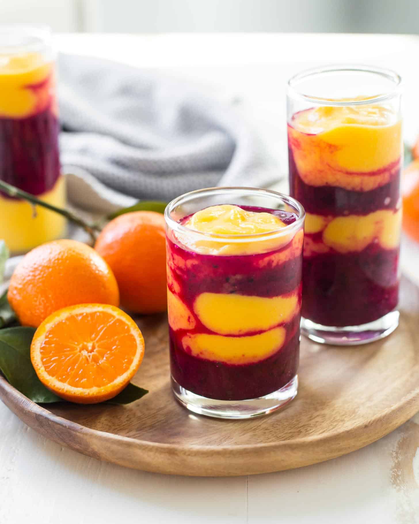 Mango, Pitaya, and Turmeric Smoothies on a wooden tray