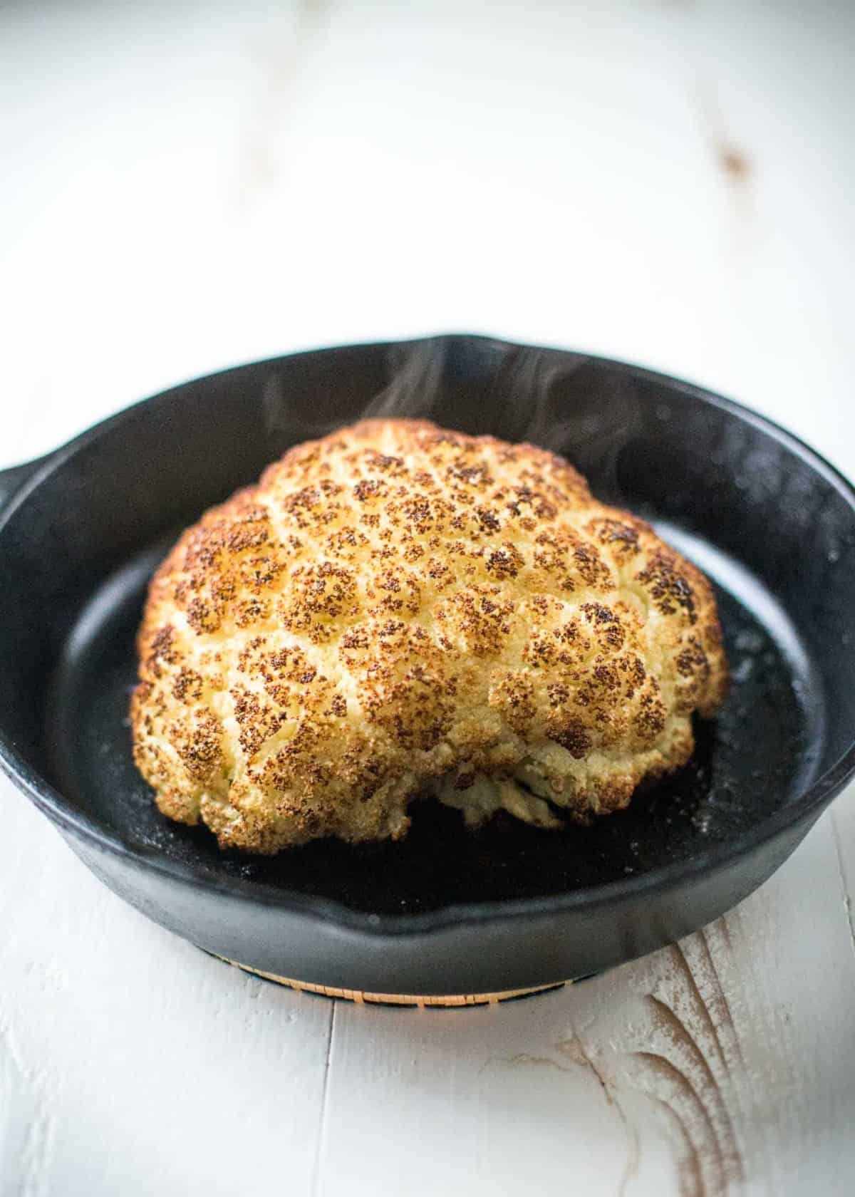 Whole Roasted Cauliflower in a skillet