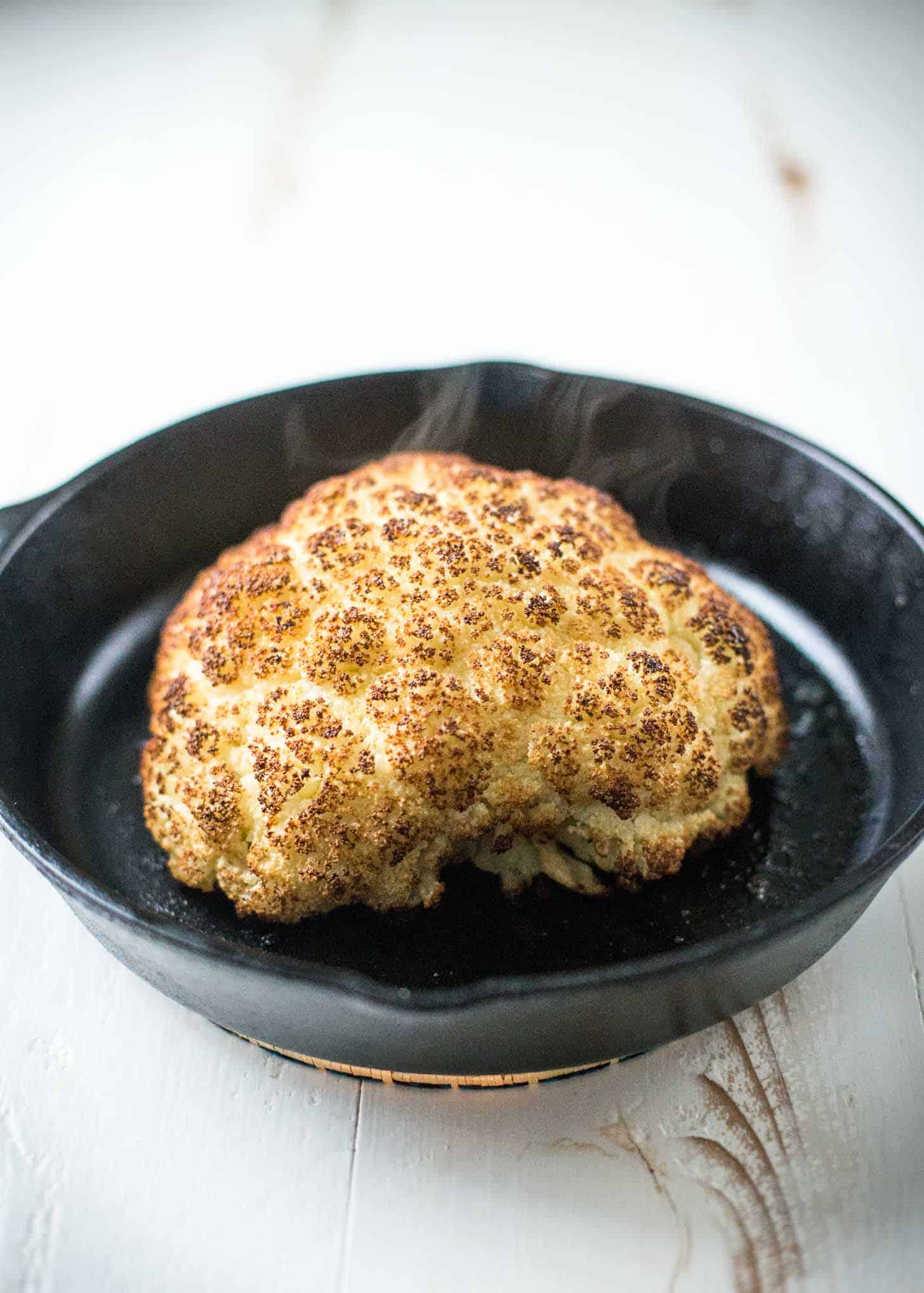 Whole Roasted Cauliflower in a cast iron skillet