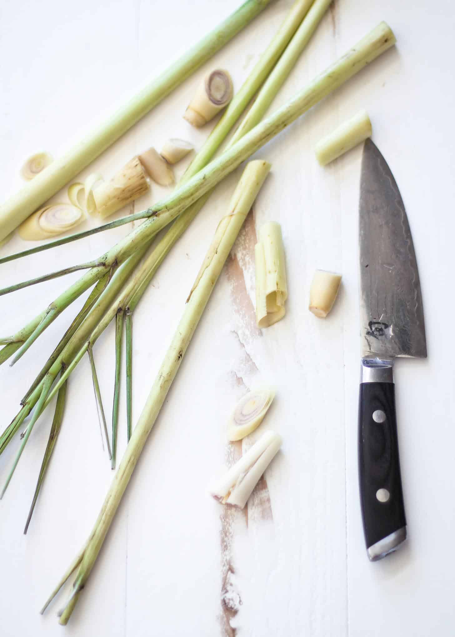 cutting lemongrass on a white countertop