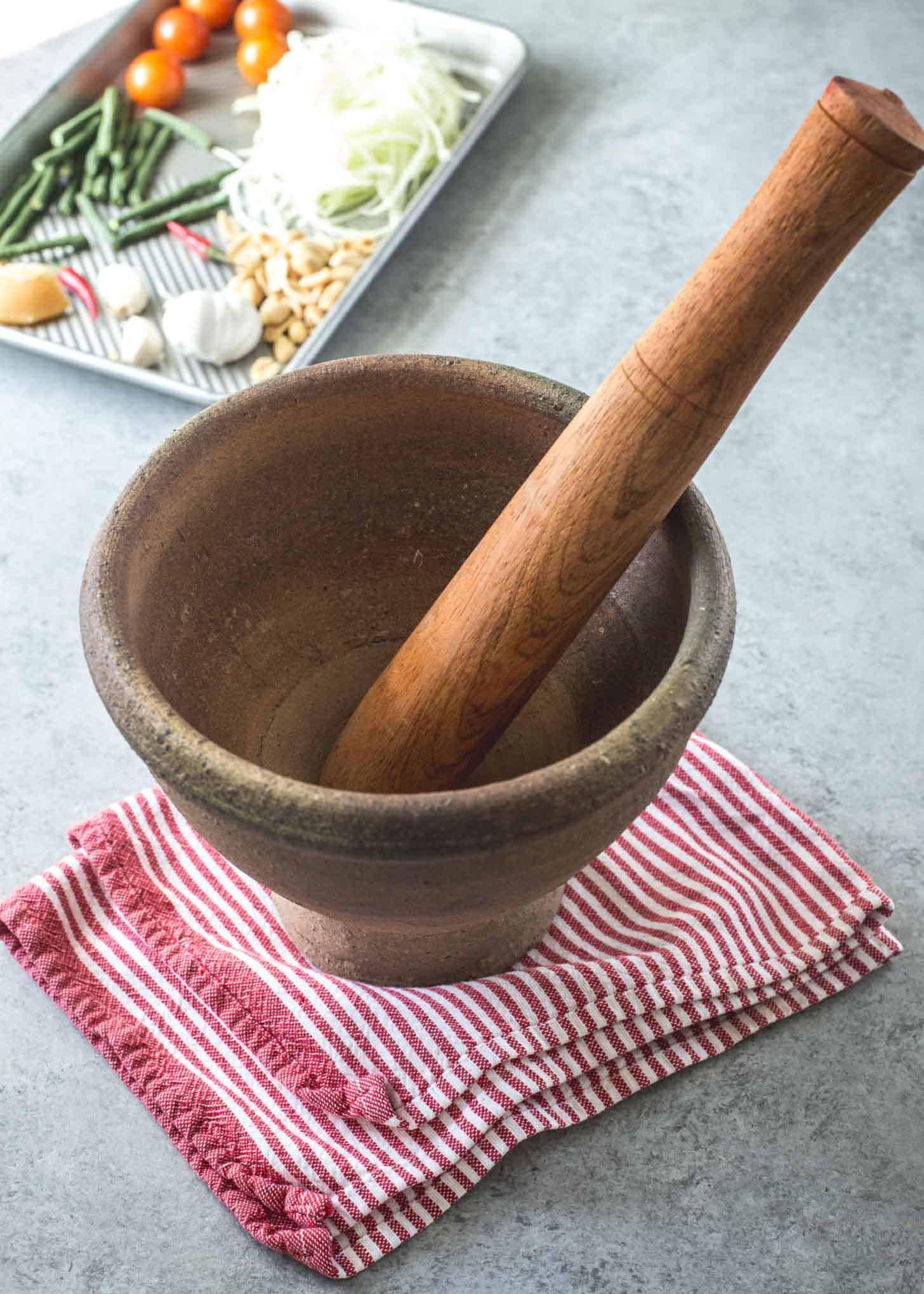 almofariz de madeira e pilão em uma mesa branca