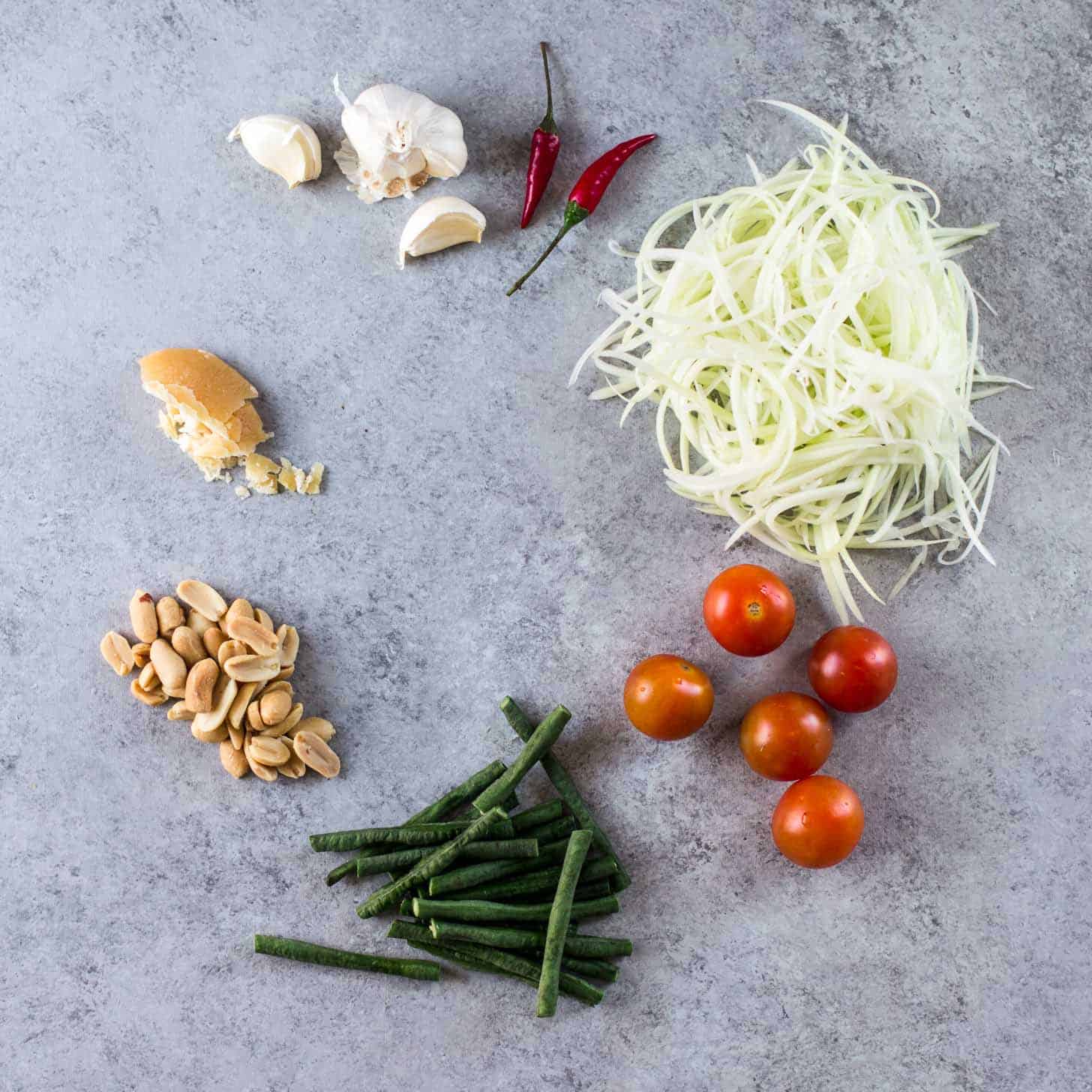 Ingredients for Green Papaya Salad on a grey countertop