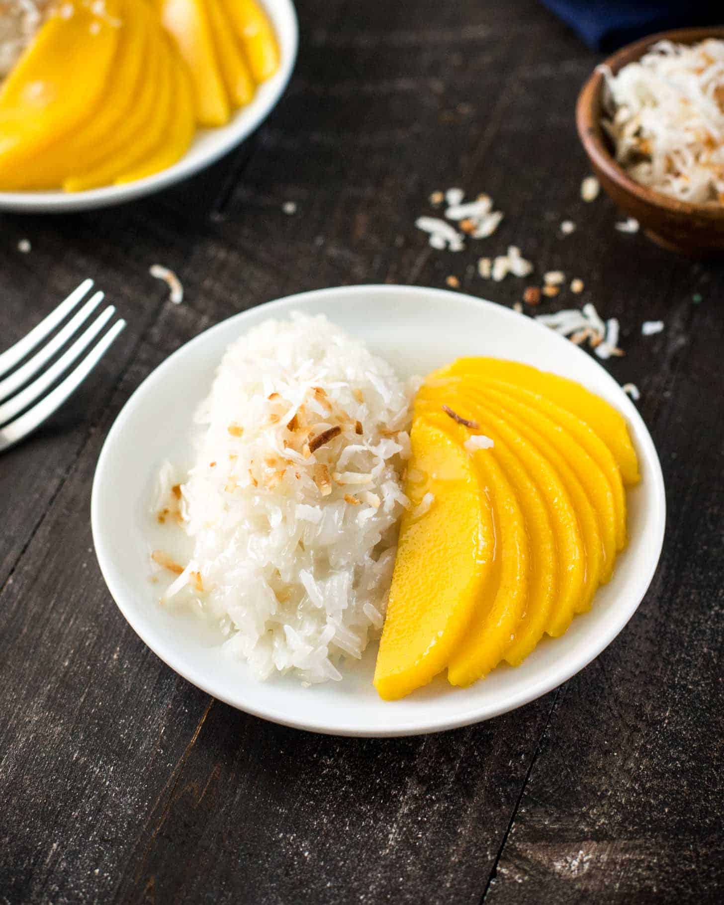 overhead image of sticky rice and mango slices on a white plate